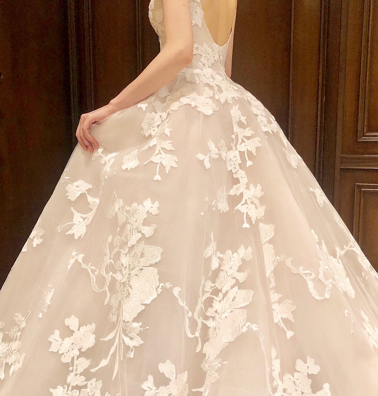 ブラッシュピンクのチュール全体に浮かび上がるレースが美しいモニークルイリエのウエディングドレス