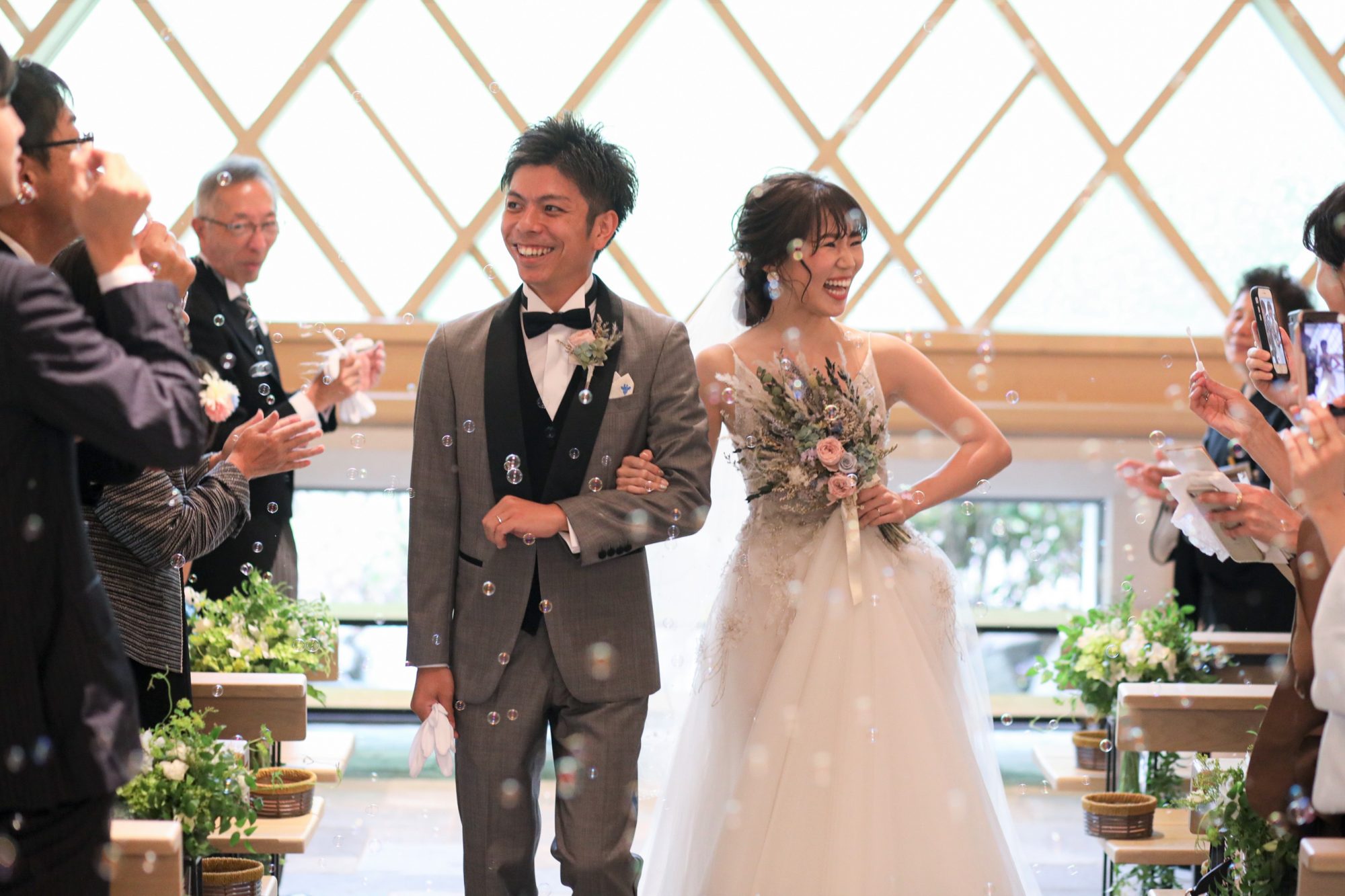 ザ・ガーデンオリエンタルオオサカの三角のチャペルでゲストとバブルシャワーに囲まれ退場するおふたり