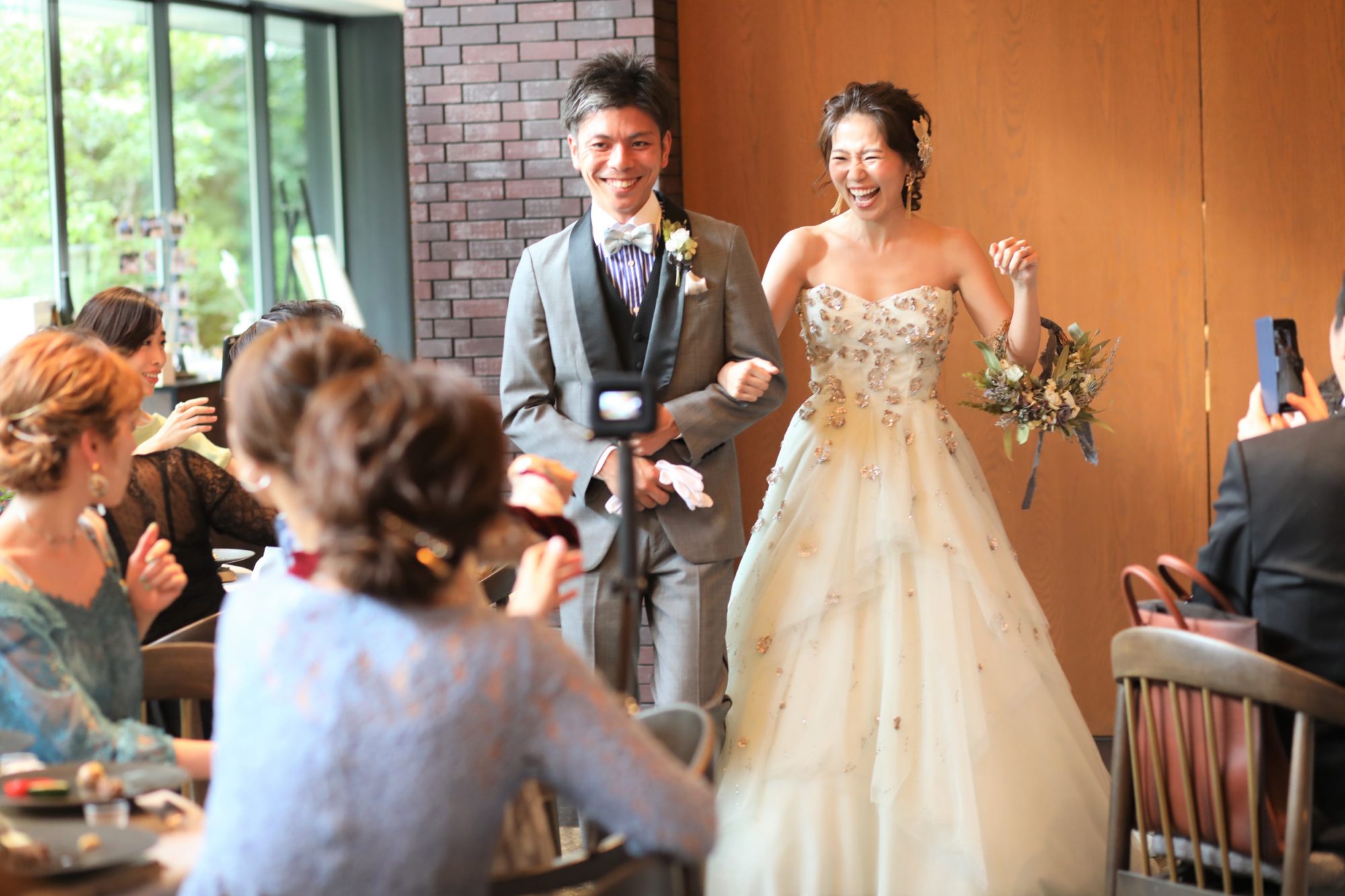 自然溢れるオリエンタルオオサカの会場にモニークルイリエのカラードレスでお色直し入場される新郎新婦様