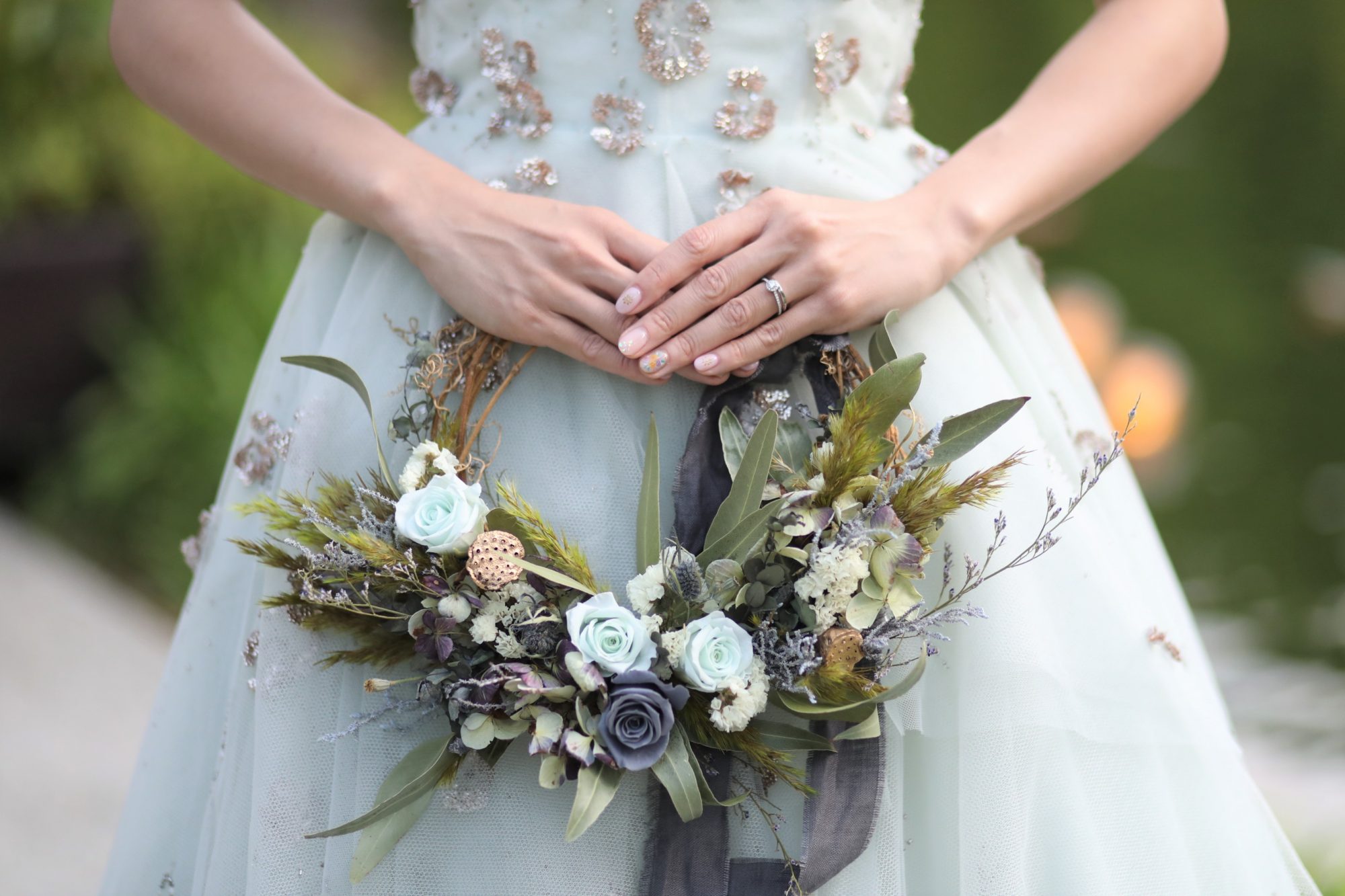 会場の緑と合わせてミントグリーンのカラードレスとリースブーケをコーディネートされたブライズスタイル