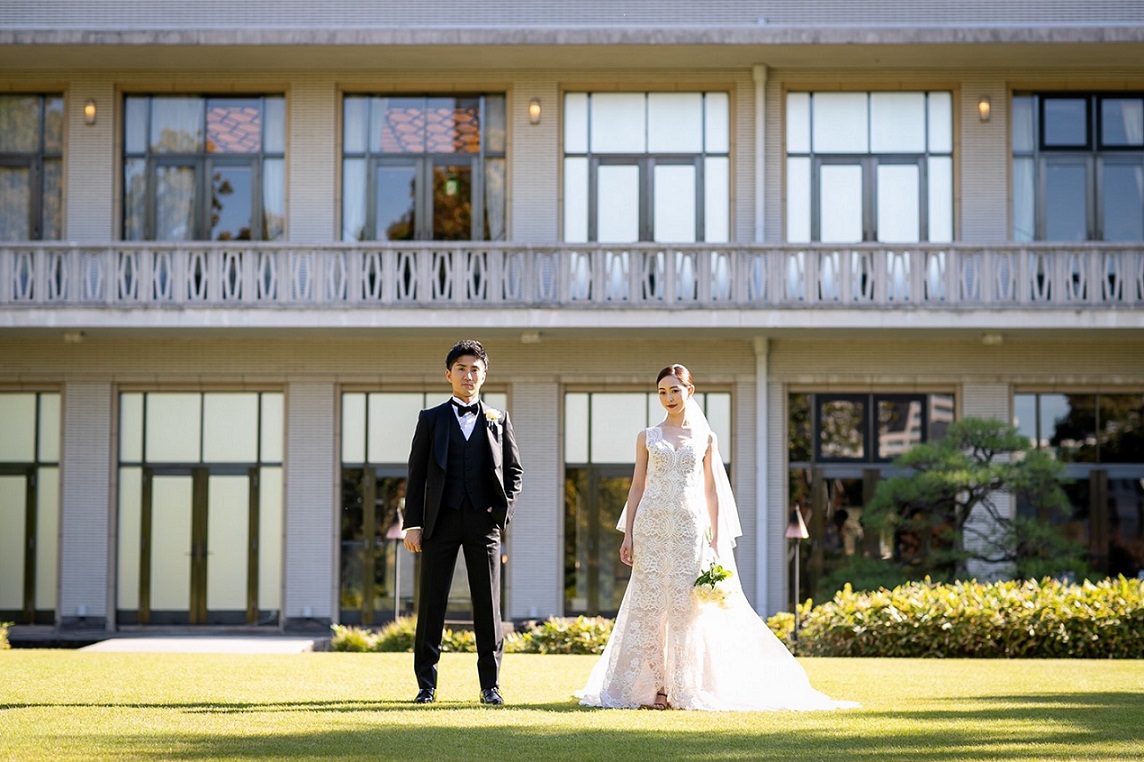 繊細なレースがグリーンの上に映えるモニーク・ルイリエのウェディングドレス