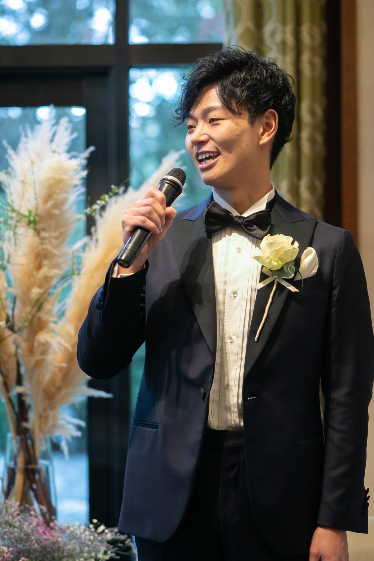 胸元にブートニアを添えたザ・トリートドレッシングのラルディーニのネイビーのタキシードをお召しになられたご新郎様