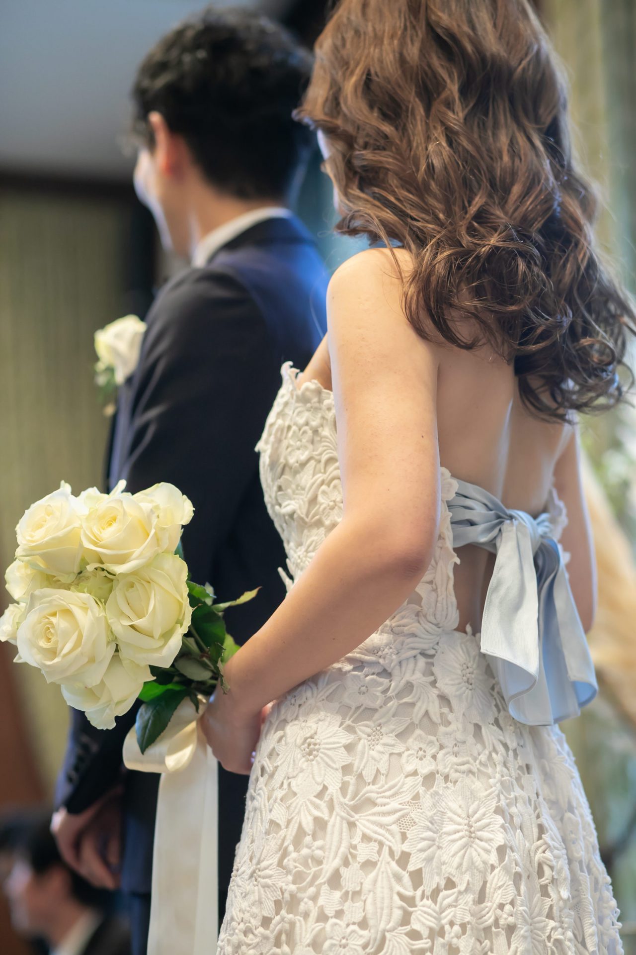 バックスタイルのペールブルーのリボンが映えるザ・トリートドレッシングのキャロリーナへレラのウェディングドレス