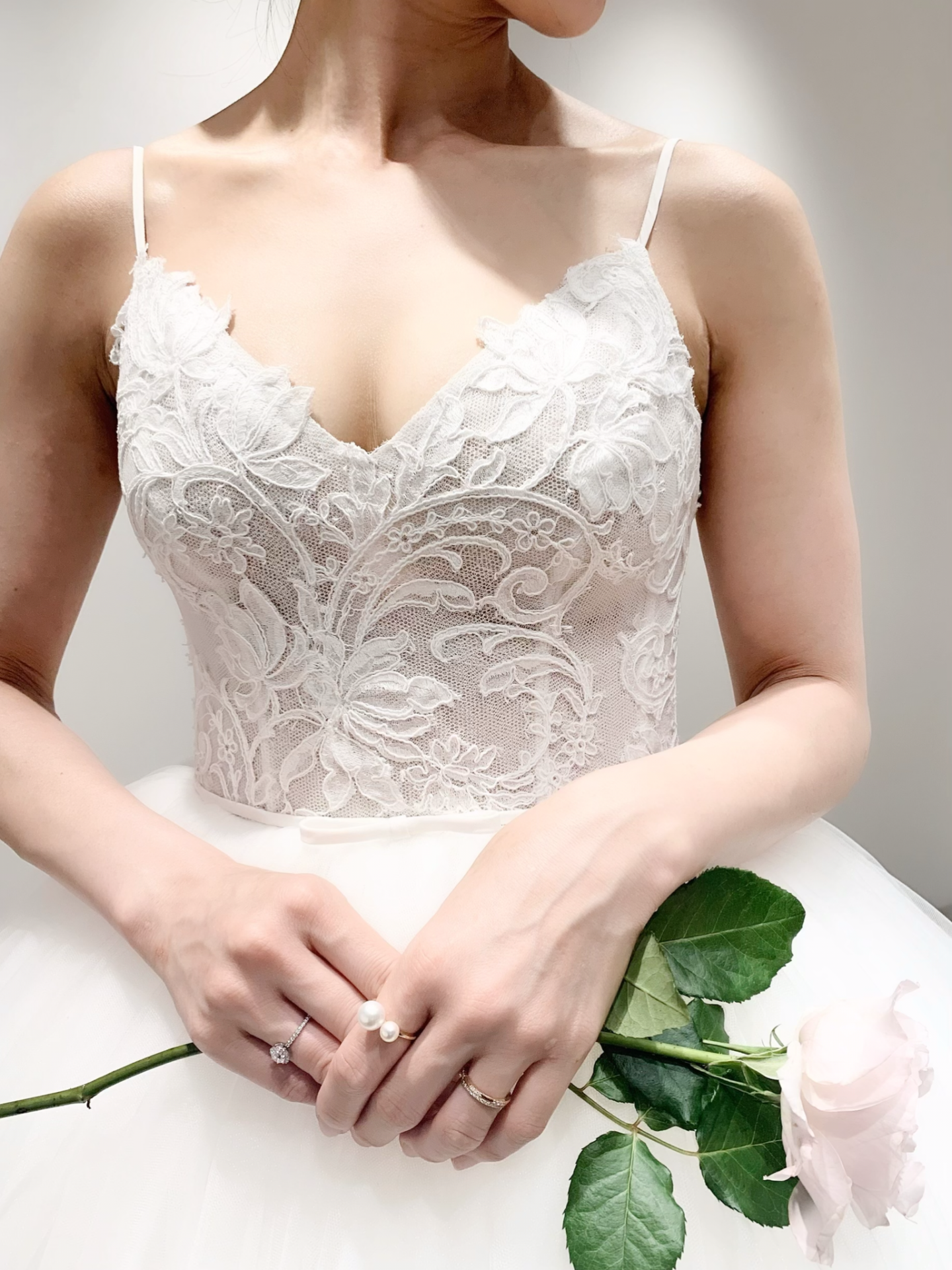 胸元の大胆なカッティングで都会的な雰囲気を演出し、レースとウエストのリボンが女性らしいTHE TREAT DRESSINGのウエディングドレス