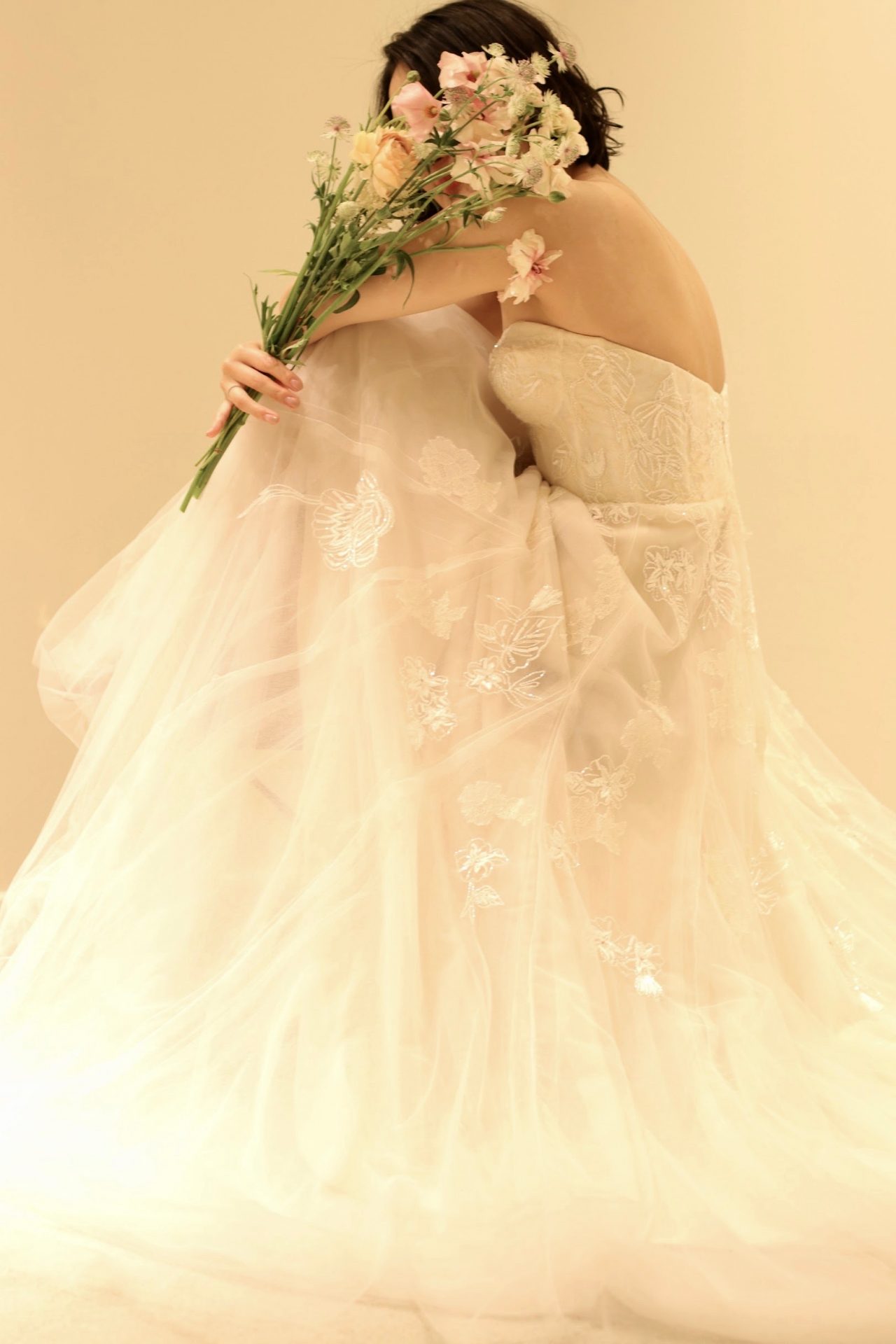 ブラッシュカラーの繊細なソフトチュールを何枚にも重ねたモニーク・ルイリエのウェディングドレスは、暖かみや柔らかさを演出するので、秋や冬のシーズンの結婚式にもオススメです