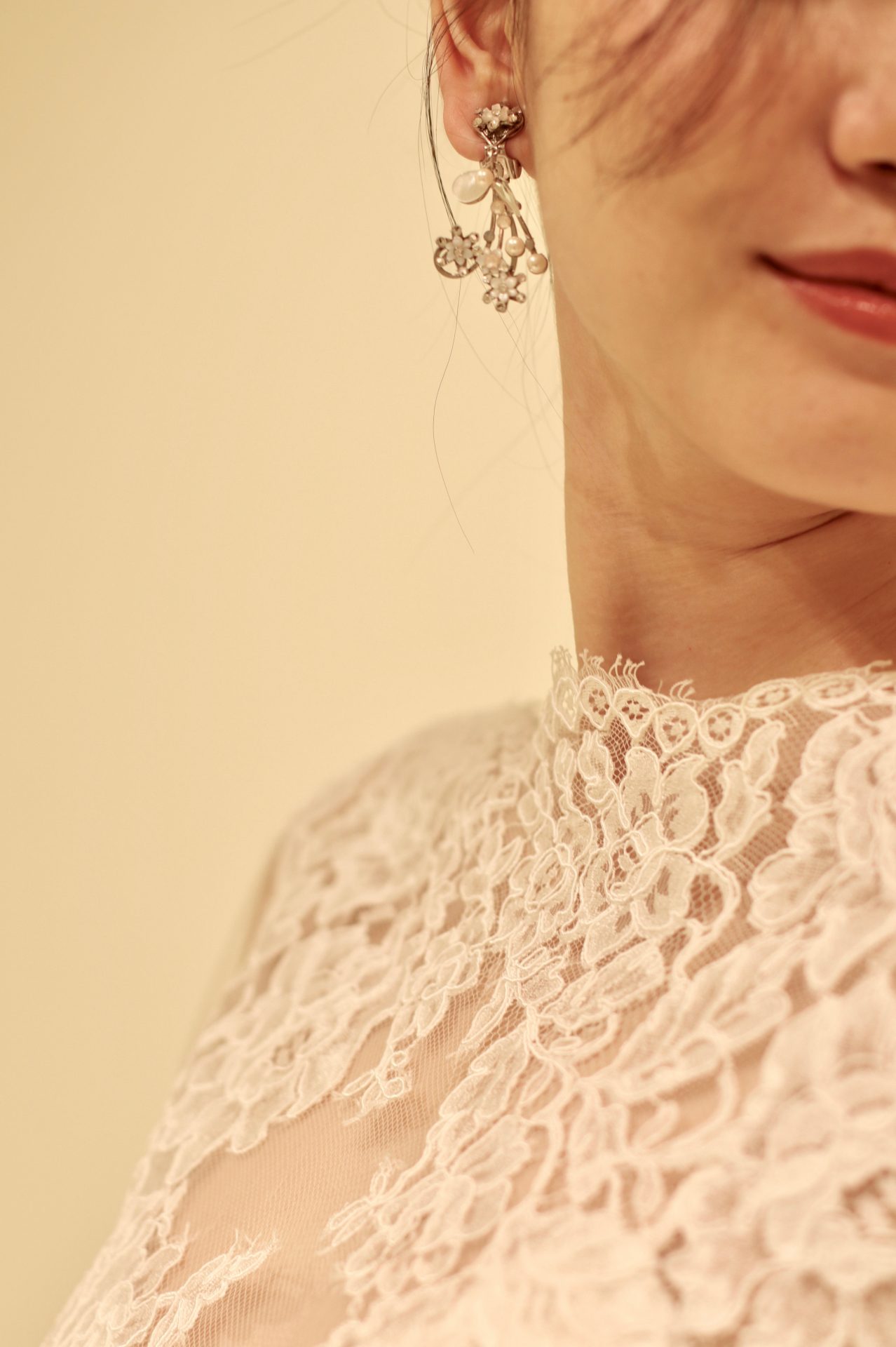 海外のトップブランド モニーク・ルイリエならではの美しいレースを使用したボレロに合わせるのは、パールやシェルで創られた小花が軽やかに揺れる繊細で華やかなイヤリングです