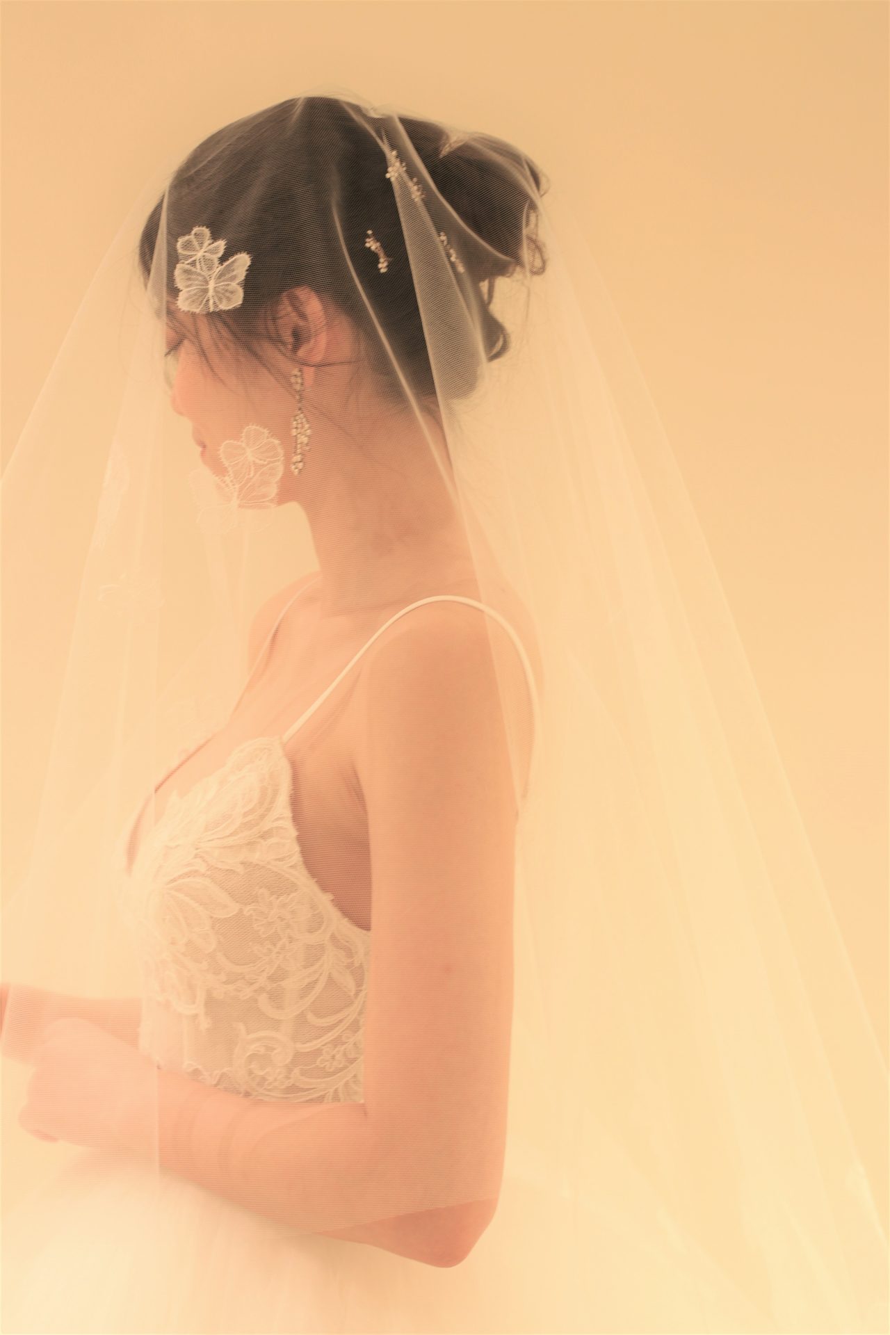 繊細な蝶々のレースをあしらったオリジナルのウェディングベールを合わせたコーディネートは、大人な上品さとあどけない可愛らしさを兼ね備えたような、ザ・トリート・ドレッシングらしい挙式スタイルをつくります