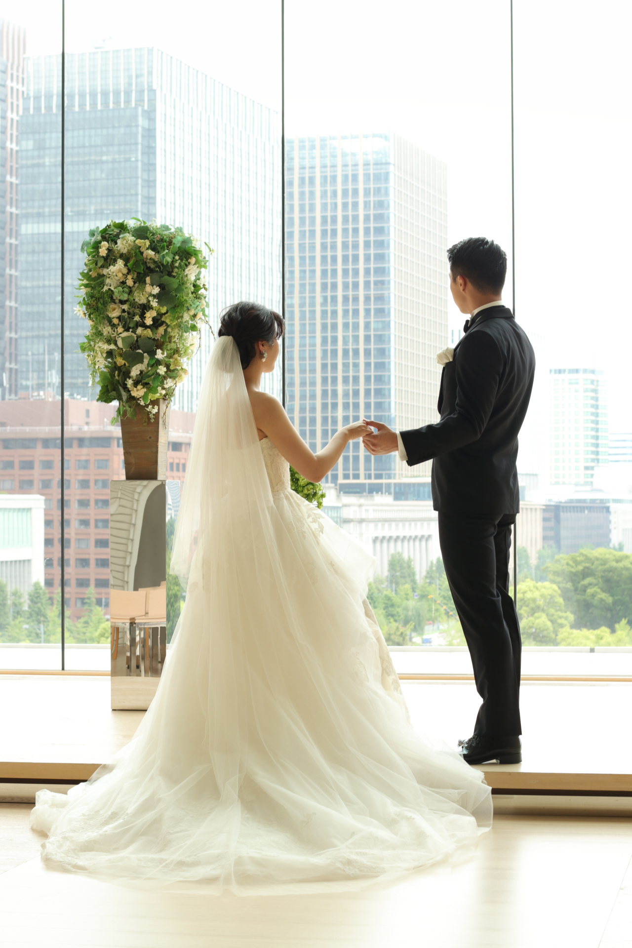人気ドレスショップ ザ・トリート・ドレッシングのオーダータキシードを着たご新郎様のエスコートで始まるのは、東京丸の内を一望するパレスホテル東京での優しい秋の自然光に包まれたセレモニーです