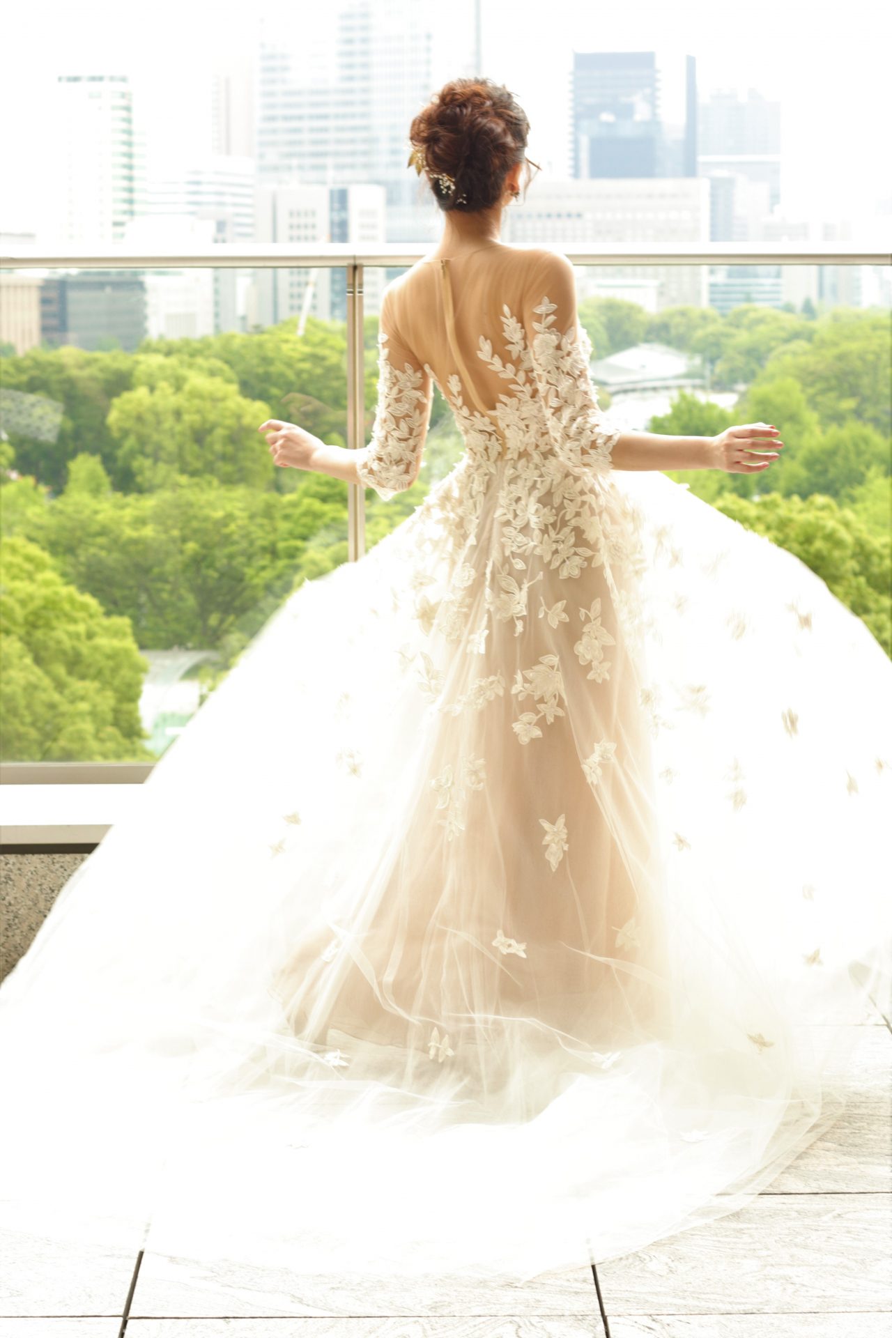 フラワーやリーフモチーフのナチュラルな刺繍が施されたシースルーのロングスリーブドレスは、クラシックな印象でありつつも重くなりすぎないため、皇居の緑が美しい夏や秋の爽やかな季節の式にもおすすめのデザインです