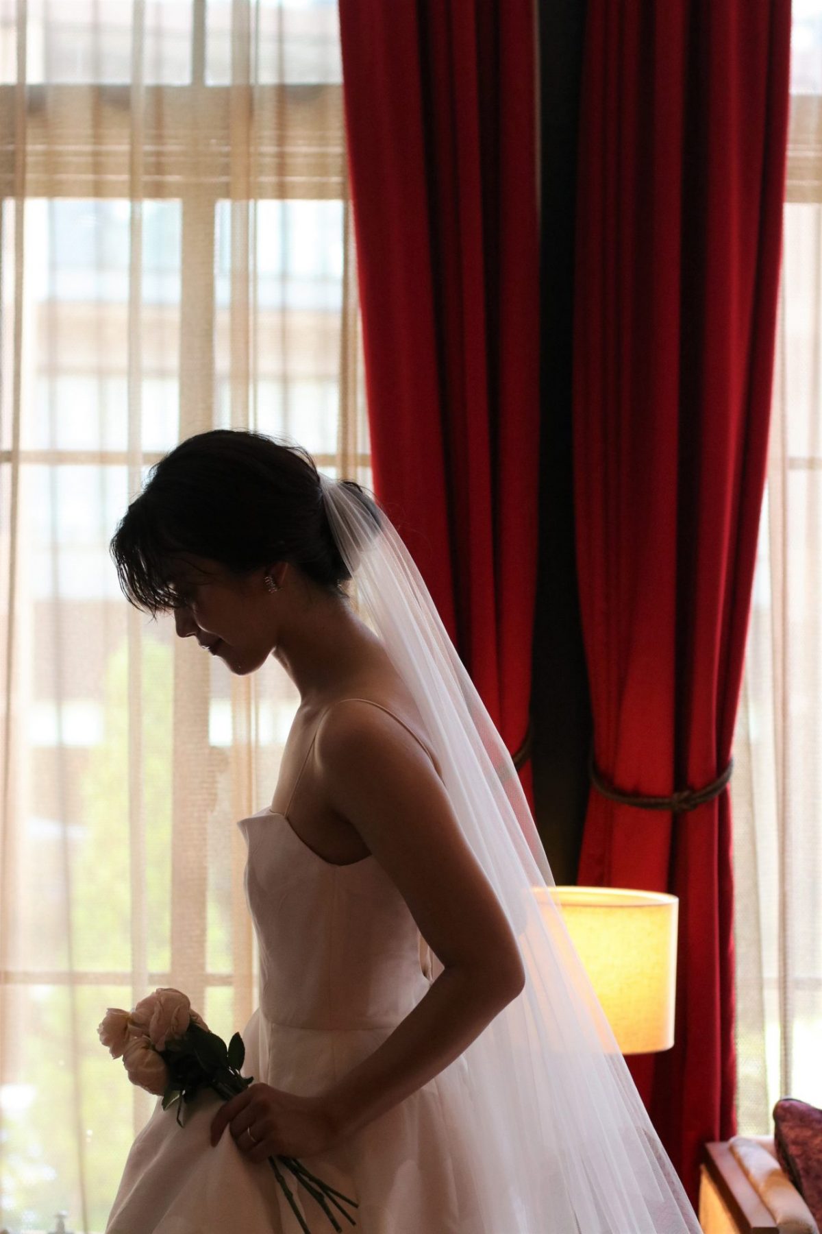 窓から柔らかい自然光が入る赤坂プリンスクラシックハウスのチャペルでは赤絨毯やカーテンにザ・トリート・ドレッシングのウェディングドレスが映え、アットホームでありながらもゲストの印象に強く残る挙式になります