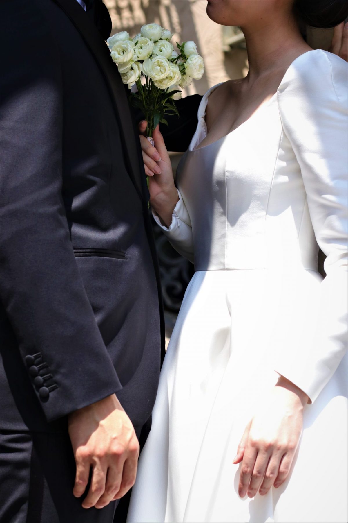 東京表参道のドレスショップTHETREATDRESSINGアディション店からご提案するのは、人気のシルクサテンのロングスリーブのウェディングドレスとフォーマルなブラックタキシードのコーディネートは秋冬の結婚式の新郎新婦様におすすめの組み合わせです