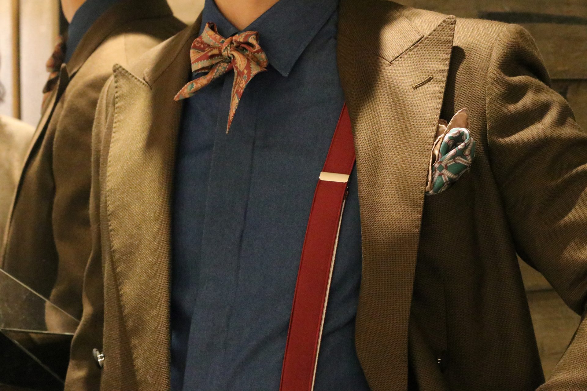 インスタグラムでも人気のTREATgentlemanがご提案するメンズウェアのコーディネートは、ブラウンのウェアに深みのあるデニムシャツとボルドーのサスペンダーやタイを合わせたシックな装いで、大人なホテルウェディングでのお色直しにおススメです。