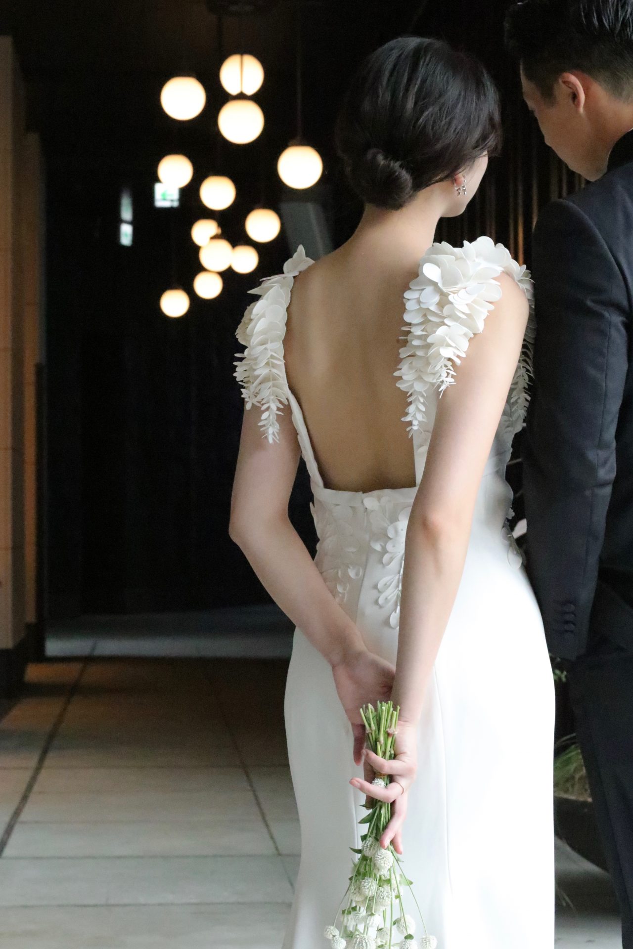 レストランウェディングやホテルウェディングにピッタリな大人な花嫁様にオススメしたいウェディングドレスは、とろみのあるクレープ素材のスレンダーラインに、背中が大きく空いたバックスタイルにショルダーには3Dフラワーのモチーフがデザインされたお洒落な1着です