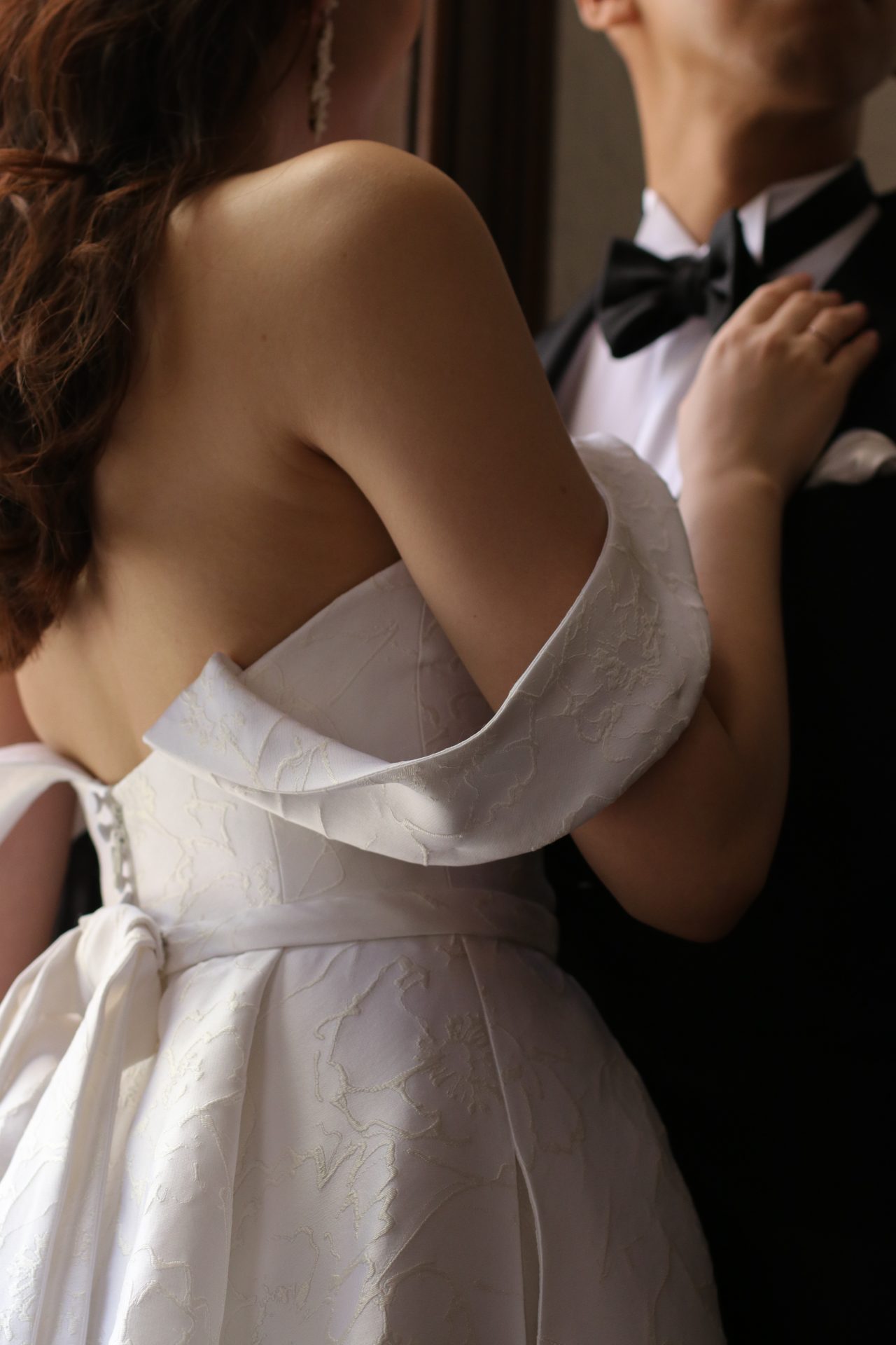 アメリカNY発の人気ドレスブランドキャロリーナ・へレラより、クラシカルなオフショルダーとくるみボタン、大人可愛い片結びリボンが印象的な新作ウェディングドレスが届きました