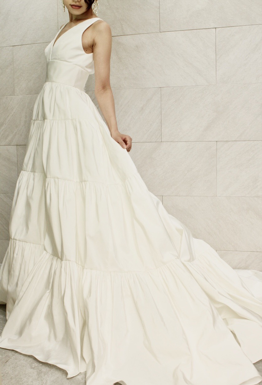AMSALE(アムサーラ)の新作ウェディングドレスをご紹介します。AMSALE(アムサーラ)からトリートアディション店入荷したウェディングドレスは、AW2020collectionからふんわりと広がるAラインのティアードデザインのスカートのウェディングドレスです。