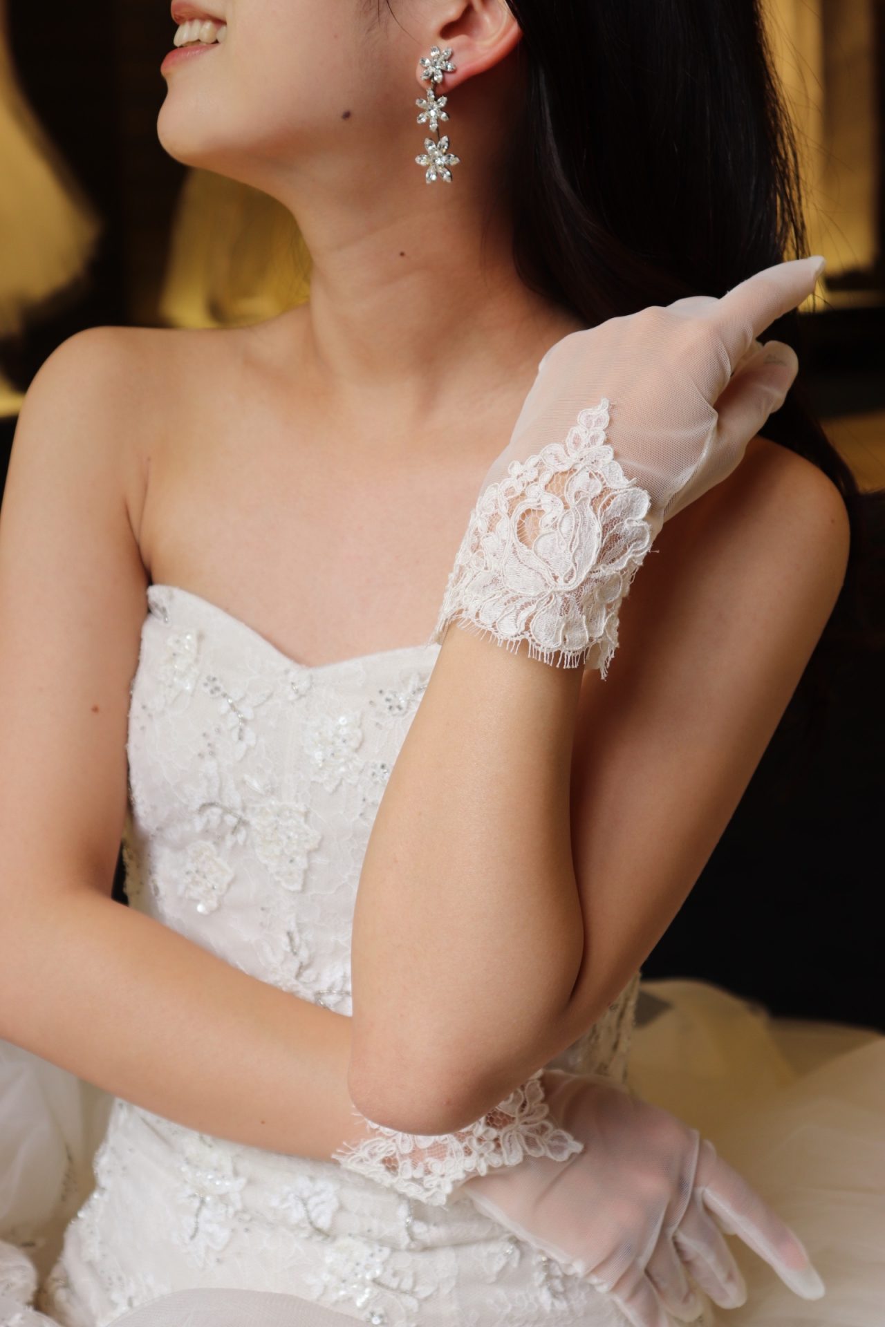 繊細なレースが美しいモニーク・ルイリエのウェディングドレスにジェニファー・ベアのイヤリングを合わせられるご新婦様