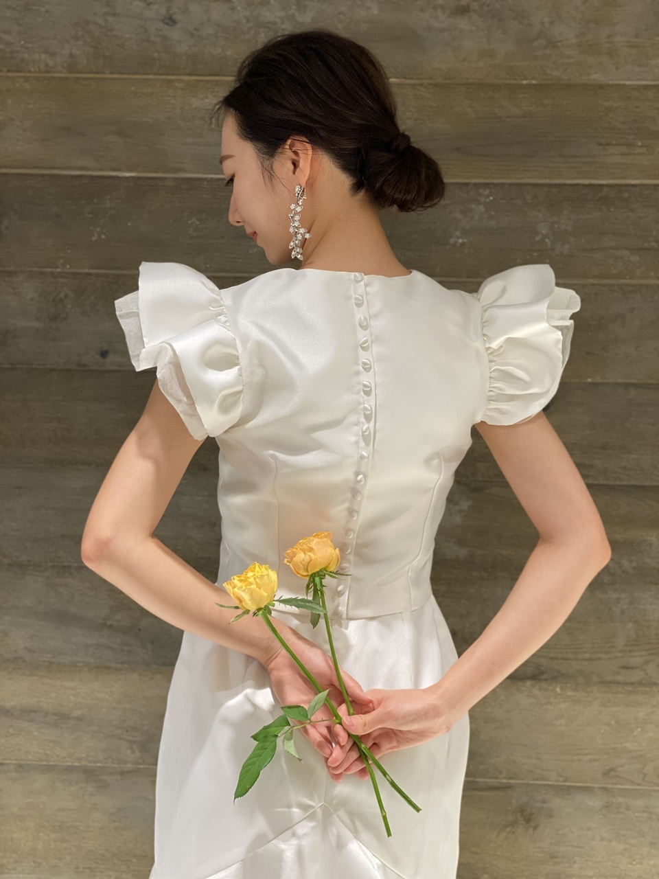 大ぶりのイヤリングが合うシンプルでオシャレで美しいスレンダーのウェディングドレス