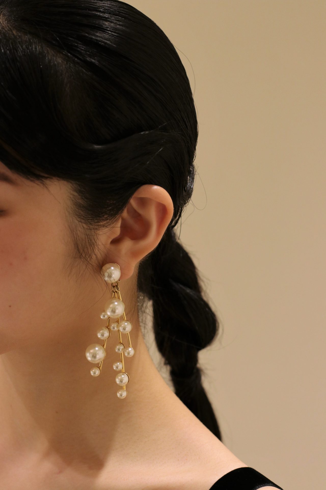 タイトにまとめたダウンスタイルには、大きさの異なるパールが施された大振りのイヤリングを合わせることで、こなれたお洒落なスタイリングに仕上がります