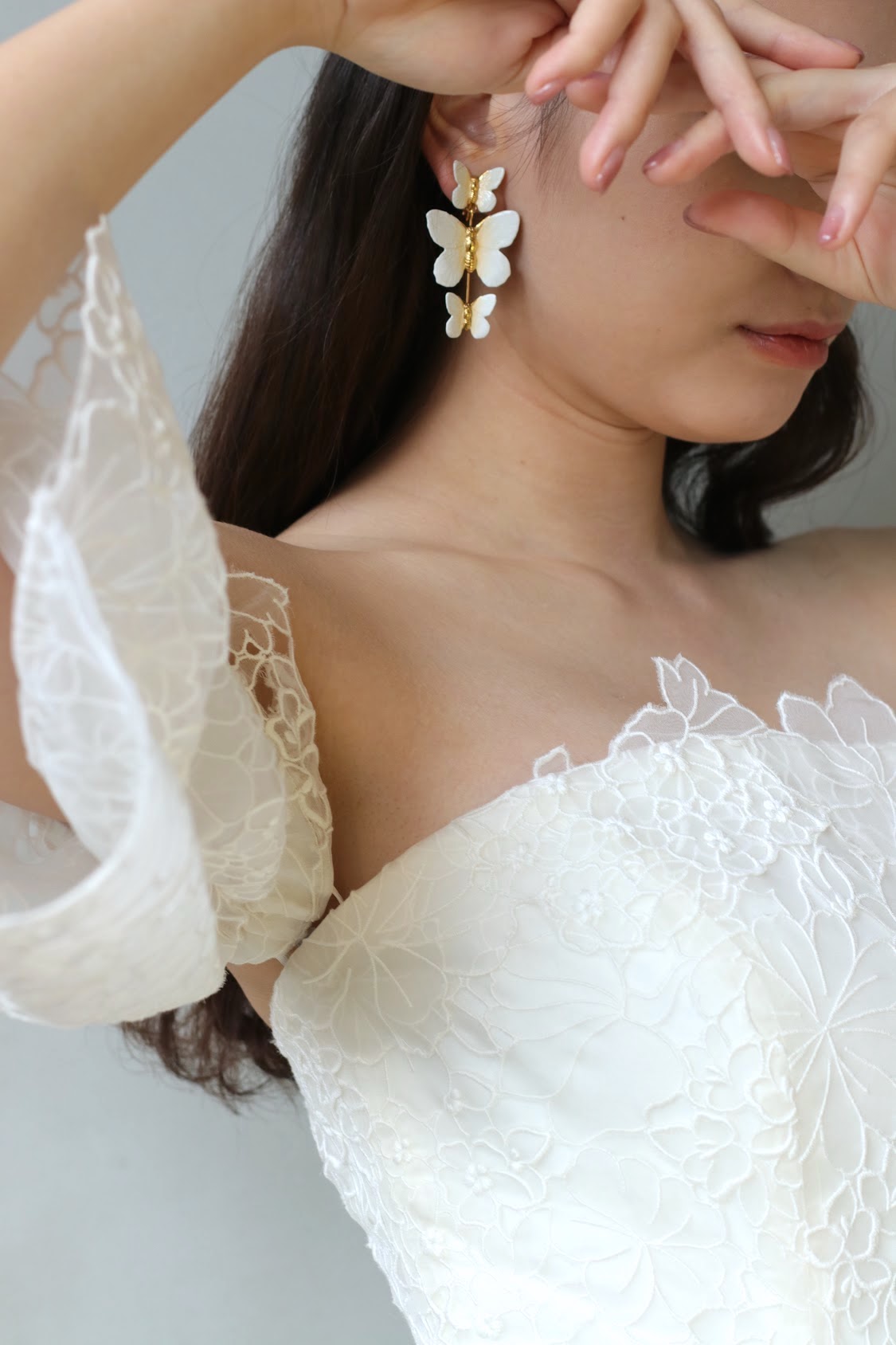 春夏の結婚式におすすめの最旬トレンドのロマンティックなドレスにはピンクのリップとネイル、蝶モチーフの白やゴールドのイヤリングを合わせると、幸福感溢れるいつまでも愛されるトータルコーディネートでありながらもフルダウンヘアにする事でモードな花嫁になることができます。