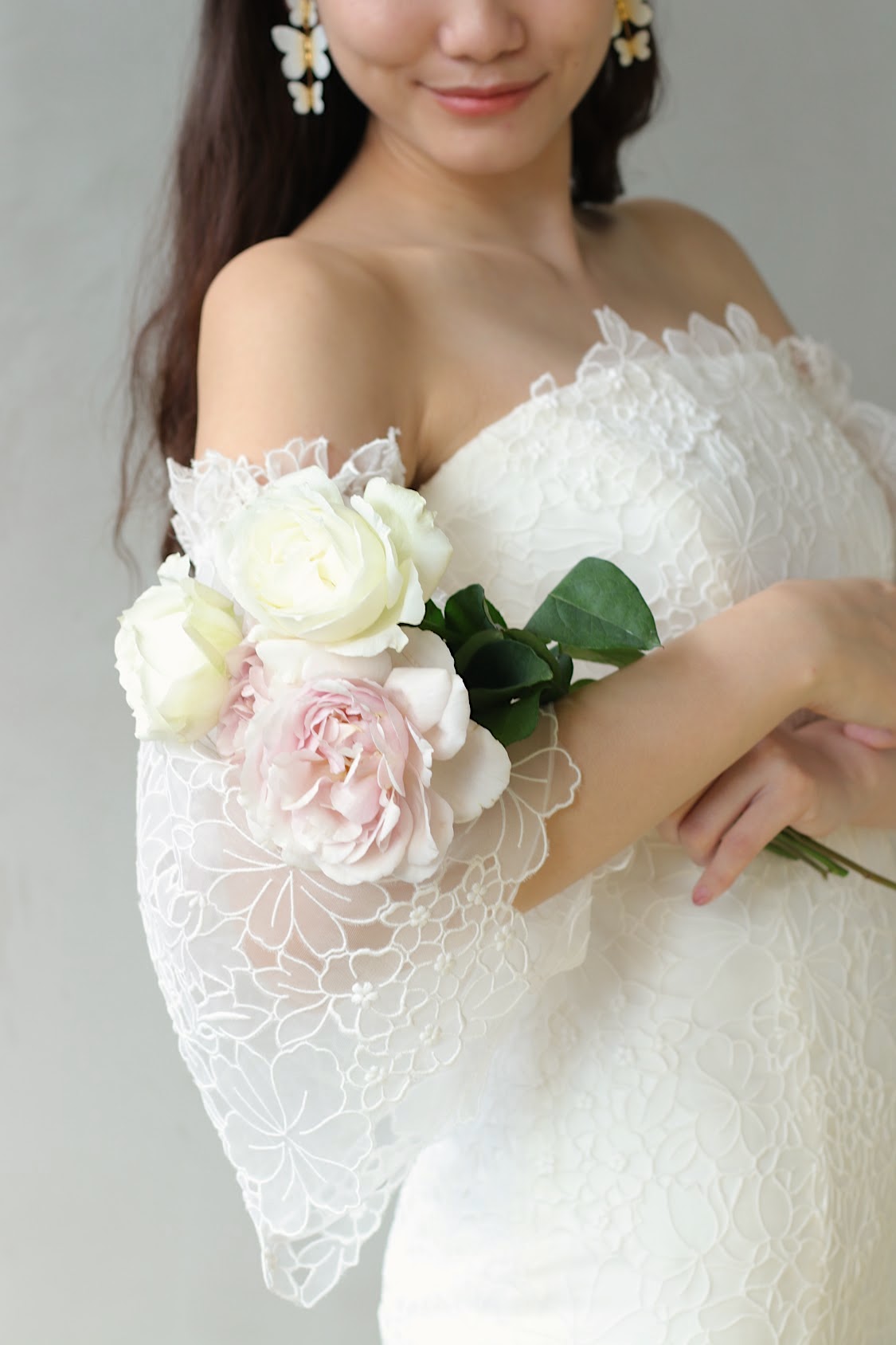 パレスホテル東京などの一流ホテルでの結婚式に人気のブランド キャロリーナ・ヘレラの新作のウェディングドレスは、トレンドの取り外しできるベルスリーブのデザインなので、二の腕が細く見える効果があり、ブーケを抱えた仕草が可憐で華やかになります