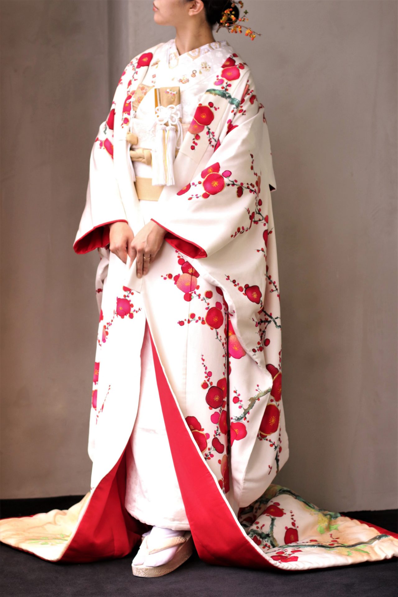 THETREATDRESSINGアディション店が春婚のお式にの方にオススメする最新和装は、白地に真紅の梅が描かれた友禅染の色打掛で、前撮りのお写真を年賀状に使用するのもおすすめです