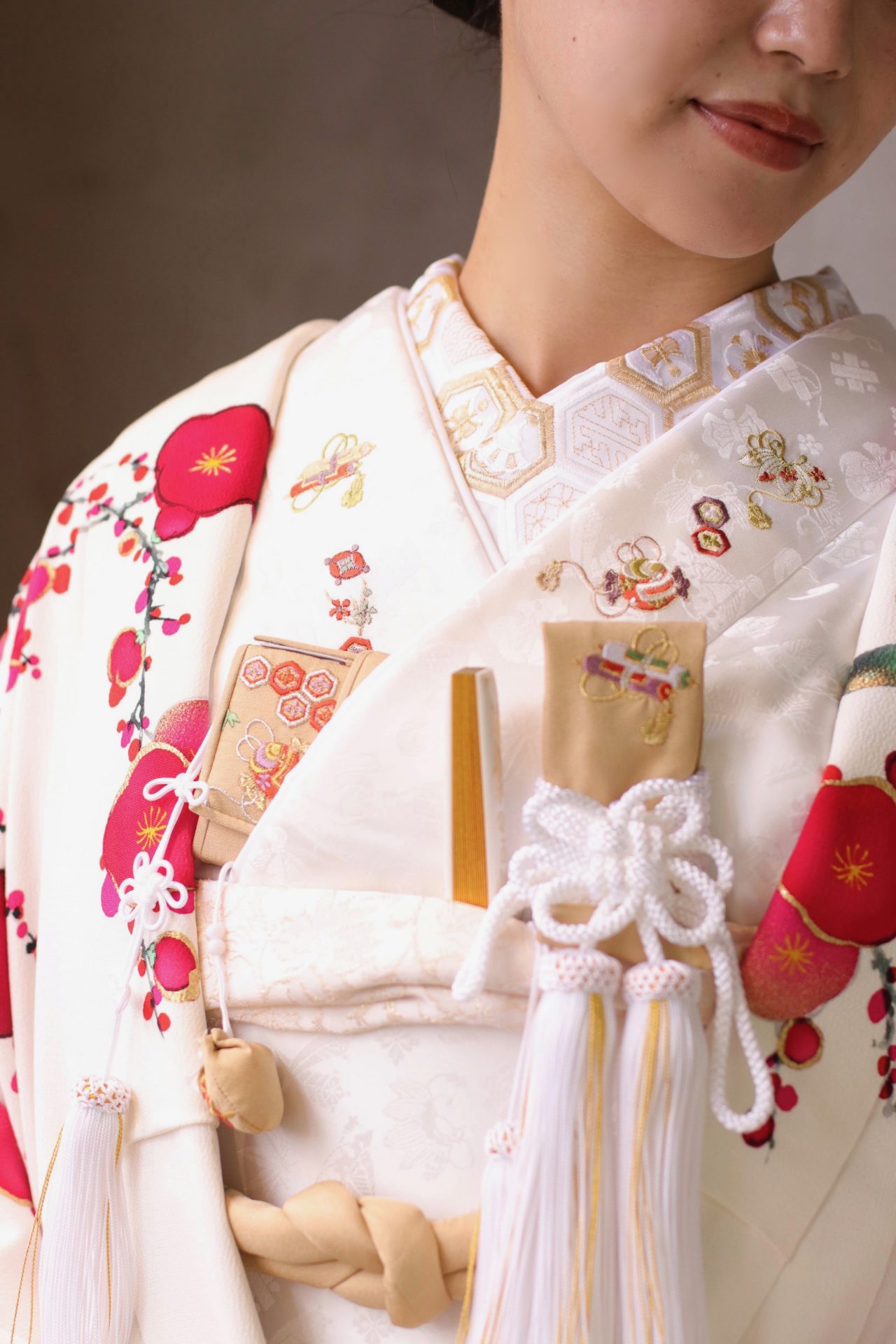 赤坂プリンスクラシックハウスの花嫁様におすすめしたいのは、繁栄を意味する亀甲文様の半襟と、福徳を呼ぶ宝尽くしの刺繍の掛下に、ベージュの和装小物を合わせた白打掛のコーディネートです