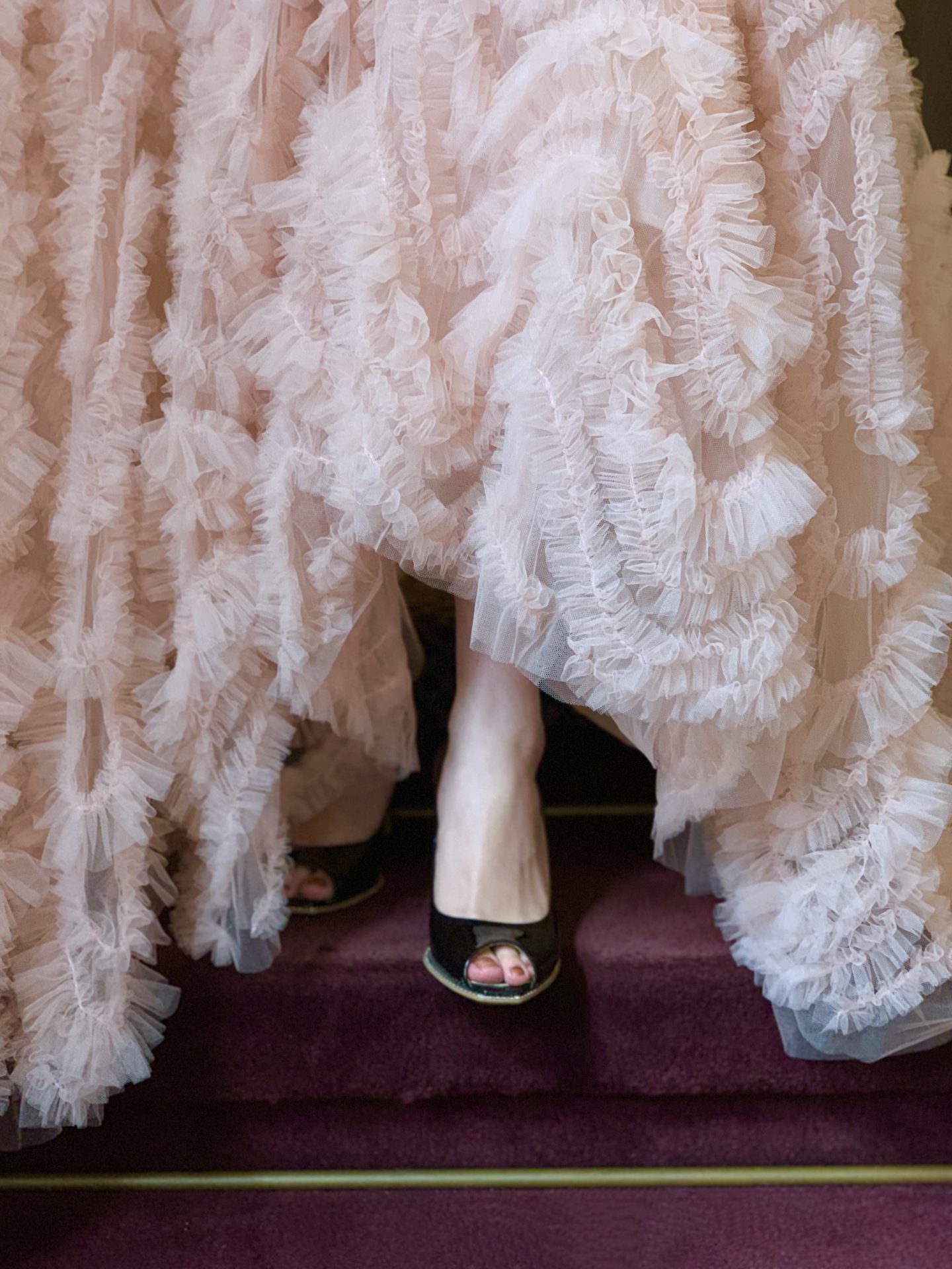 THE TREAT DRESSING(ザ・トリート・ドレッシング)のピンクのカラードレスの裾元からブラックのオープントゥのシューズをのぞかせるおしゃれなお色直しのコーディネート