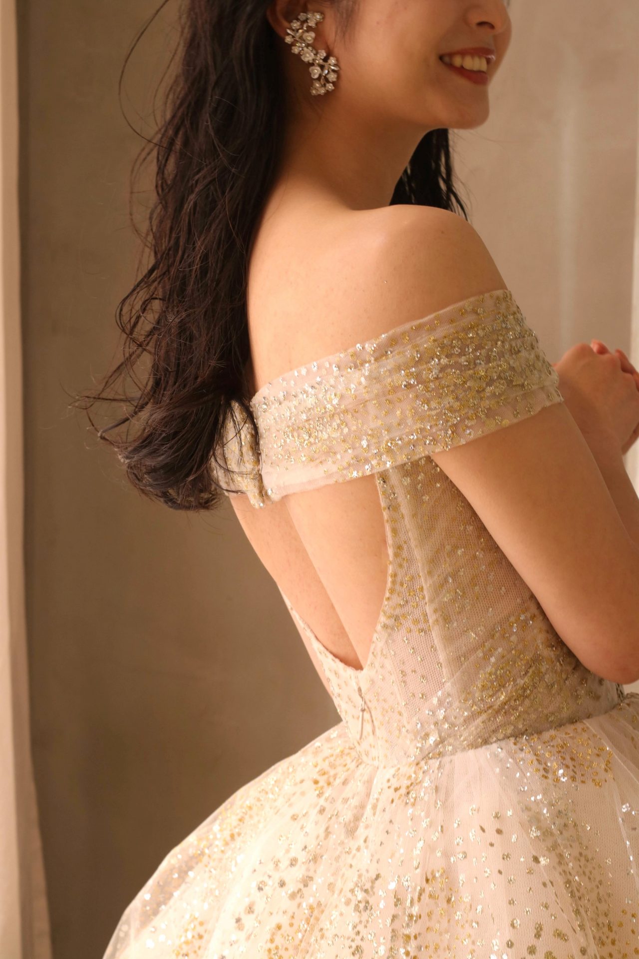 後ろ姿に視線を集める、背中の空いたバックコンシャスなお色直しのカラードレスにおすすめのコーディネートはダウンスタイルで大ぶりのフラワーモチーフのイヤリングを合わせた大人ナチュラルな雰囲気です