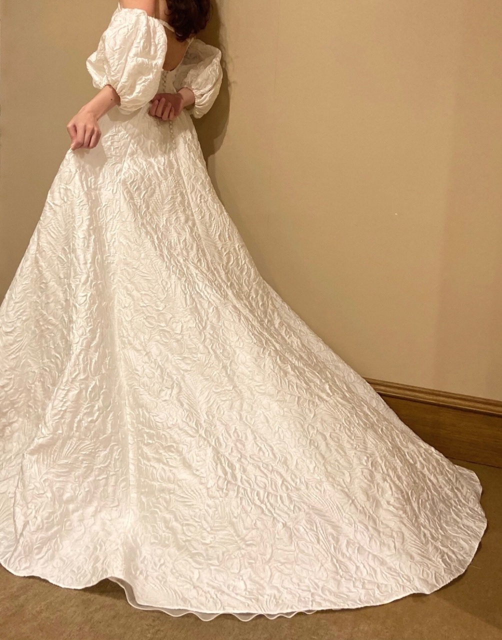 フラワーモチーフのジャガード素材が愛らしく、柔らかでふんわりとしたボリュームのあるウエディングドレス