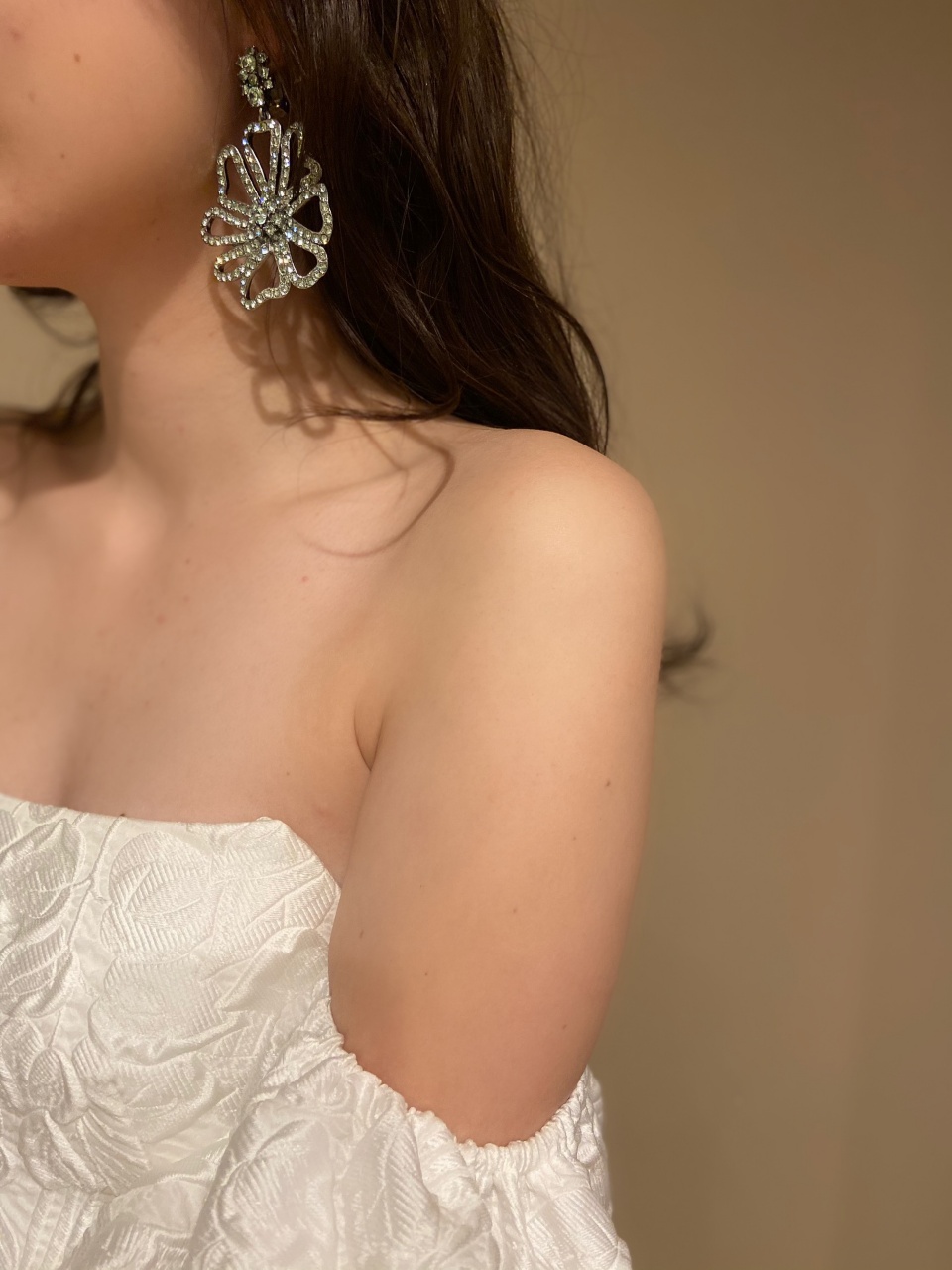 クリアブルーの大振りなフラワーモチーフのイヤリングを合わせ、モダンなドレスをよりファッショナブルな印象に