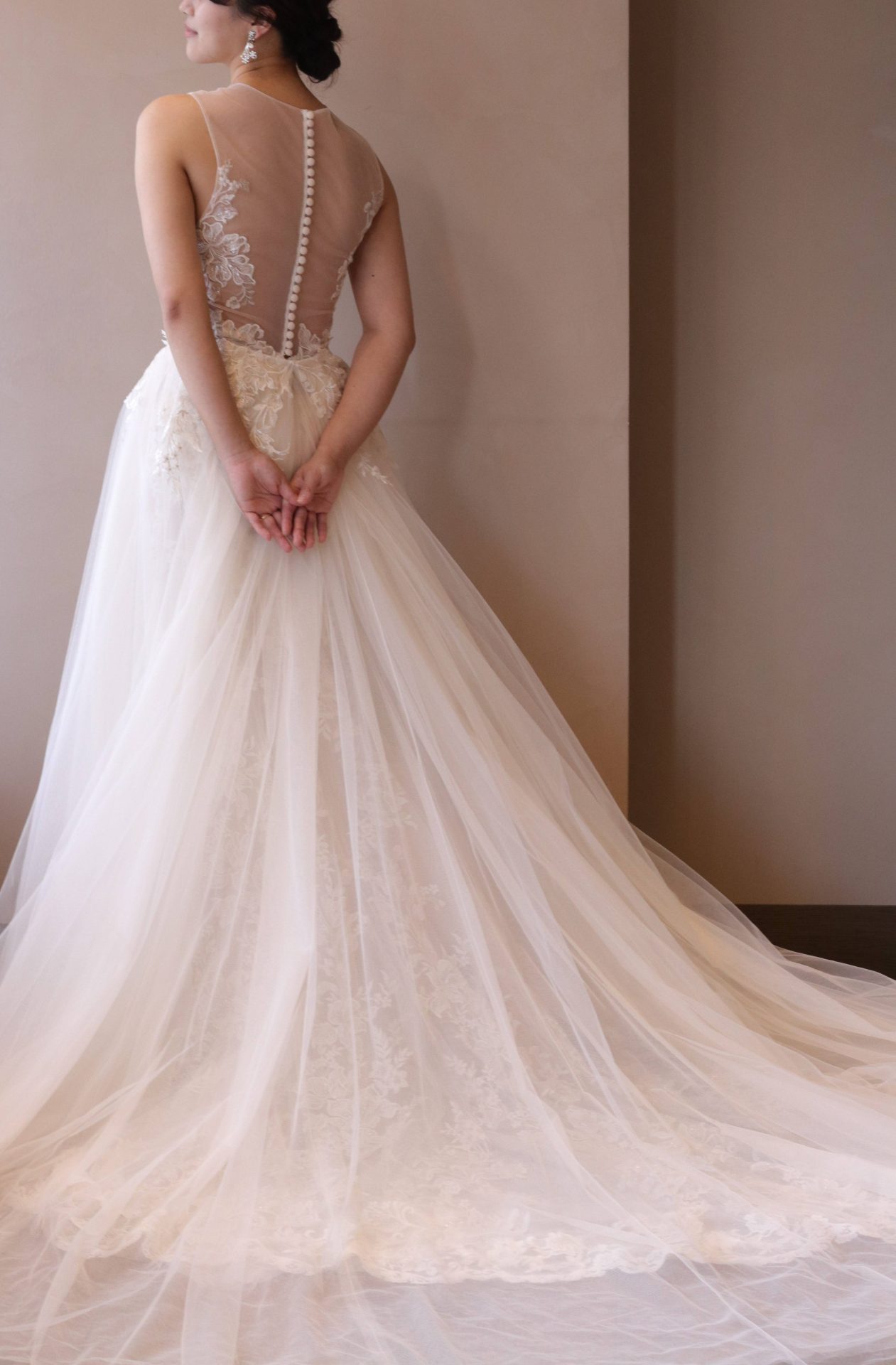 ブリスモニークルイリエの2WAYドレスは、チュールのオーバースカートを重ねることで神秘的な後ろ姿を演出し、パレスホテル東京などの洗練されたチャペルによく合います