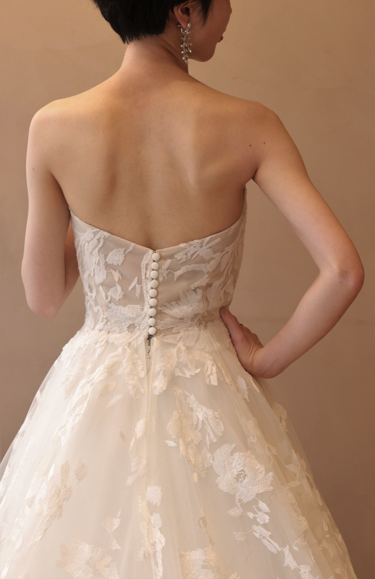 日本で唯一、ザトリートドレッシングでお取り扱いのあるブリスモニークルイリエの販売ドレスは、繊細な総レースとバックスタイルに施されたくるみボタンが女性心をくすぐる特別な1着です