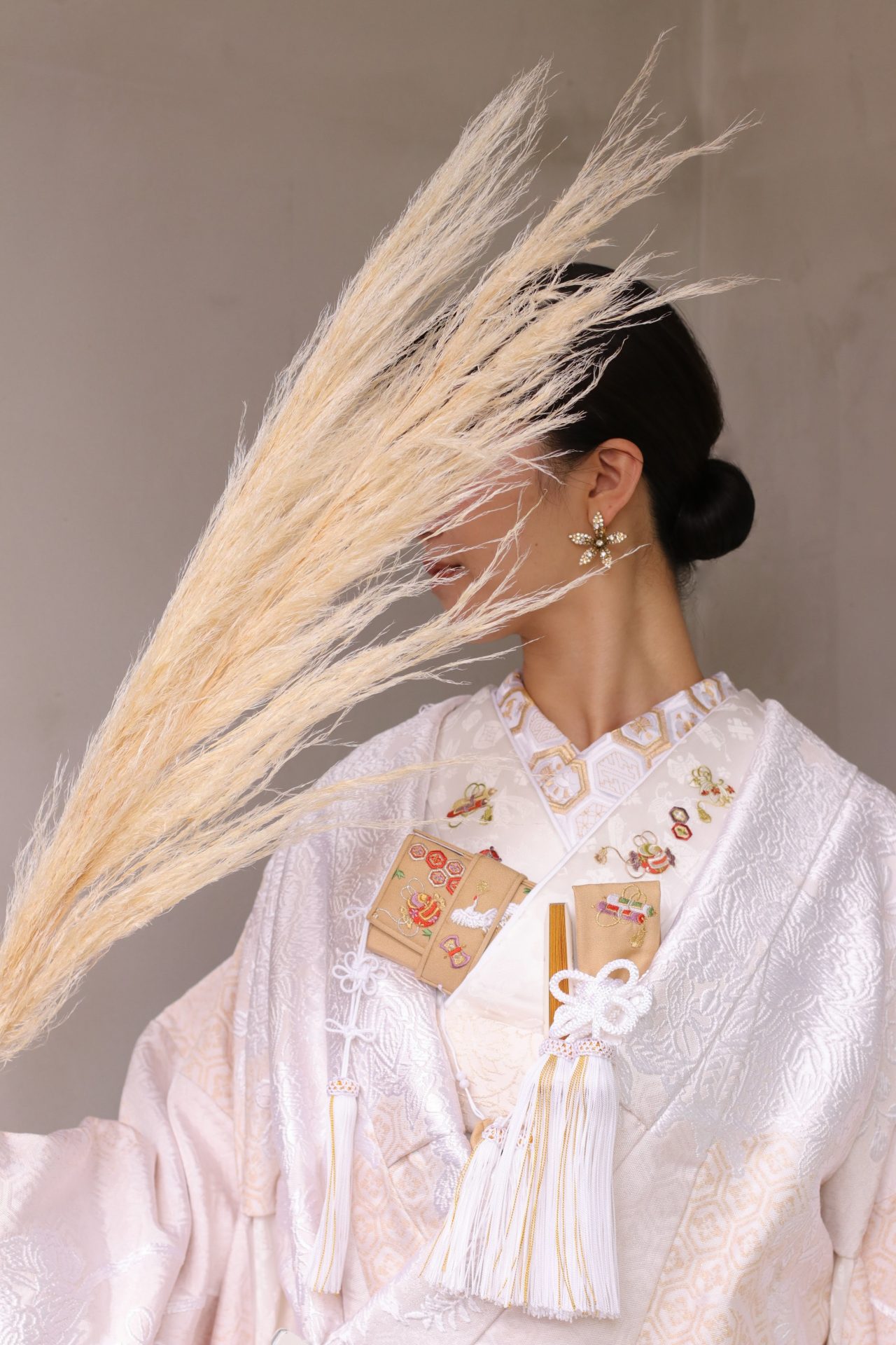 お洒落な花嫁様にオススメしたいザトリートドレッシングの亀甲文様の新作白無垢に合わせるコーディネートは、金糸と柔らかい色合いの宝尽くしの文様のお小物でお顔回りを華やかに、そしてゴールドのお花のイヤリングを合わせて大人っぽくモダンな印象に仕上げました