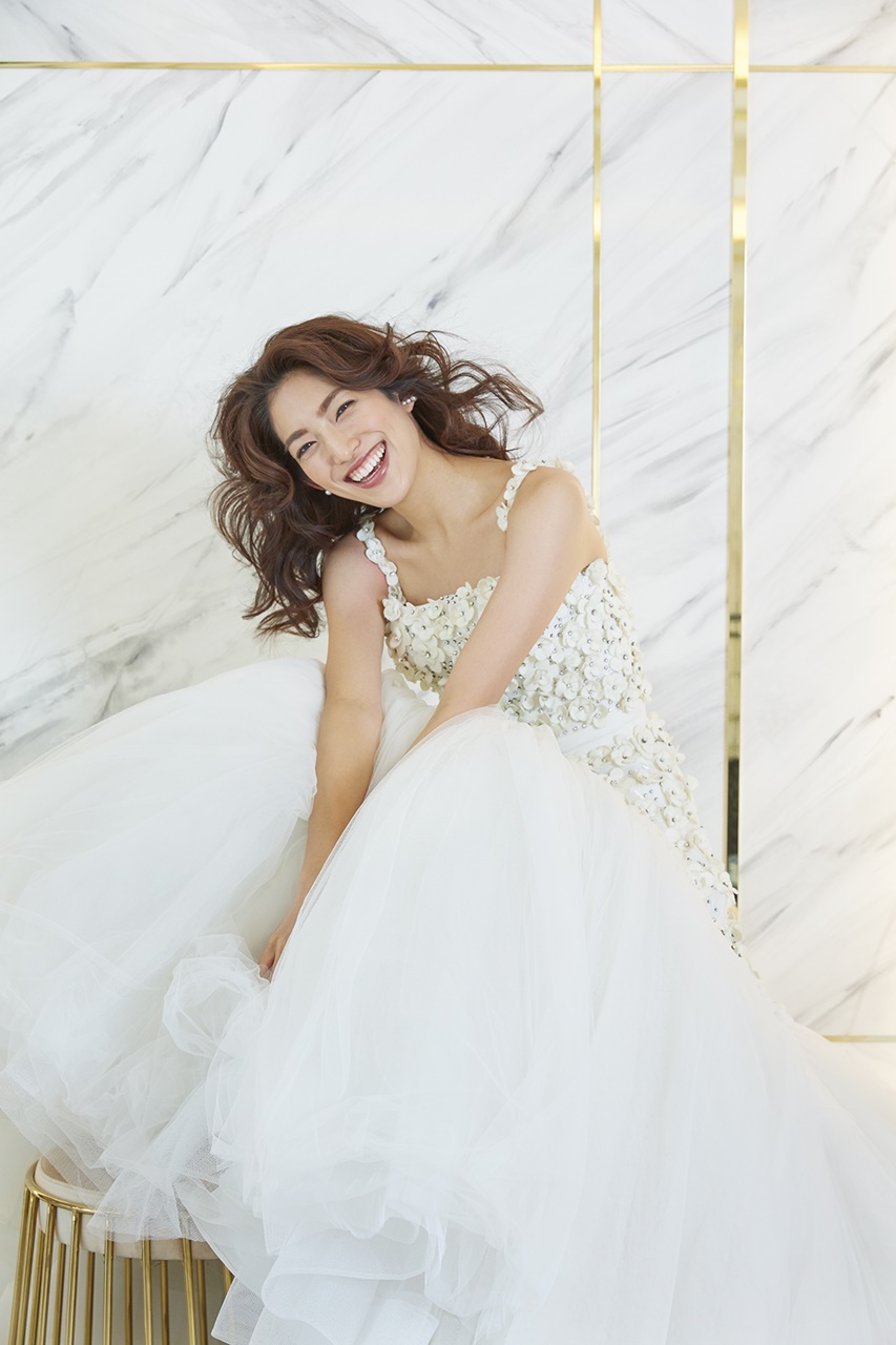 望月芹名さんが着ているドレスは3Dのフラワーモチーフが付いたヴィクター&ロルフ・マリアージュの白いウェディングドレスドレス