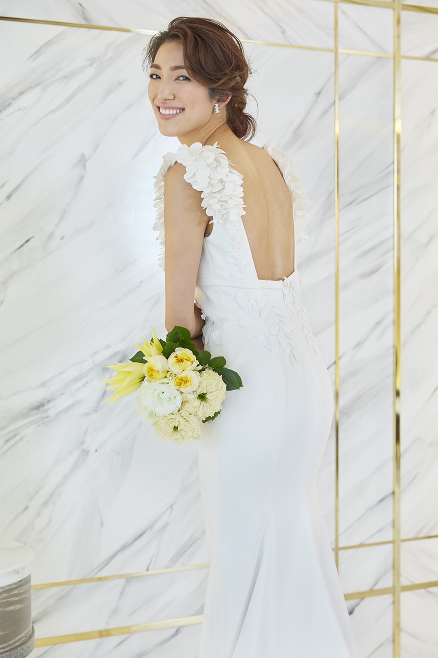 望月芹名さんが着ているドレスは3Dの藤の花のモチーフが付いたヴィクター&ロルフ・マリアージュの白いウェディングドレスドレス