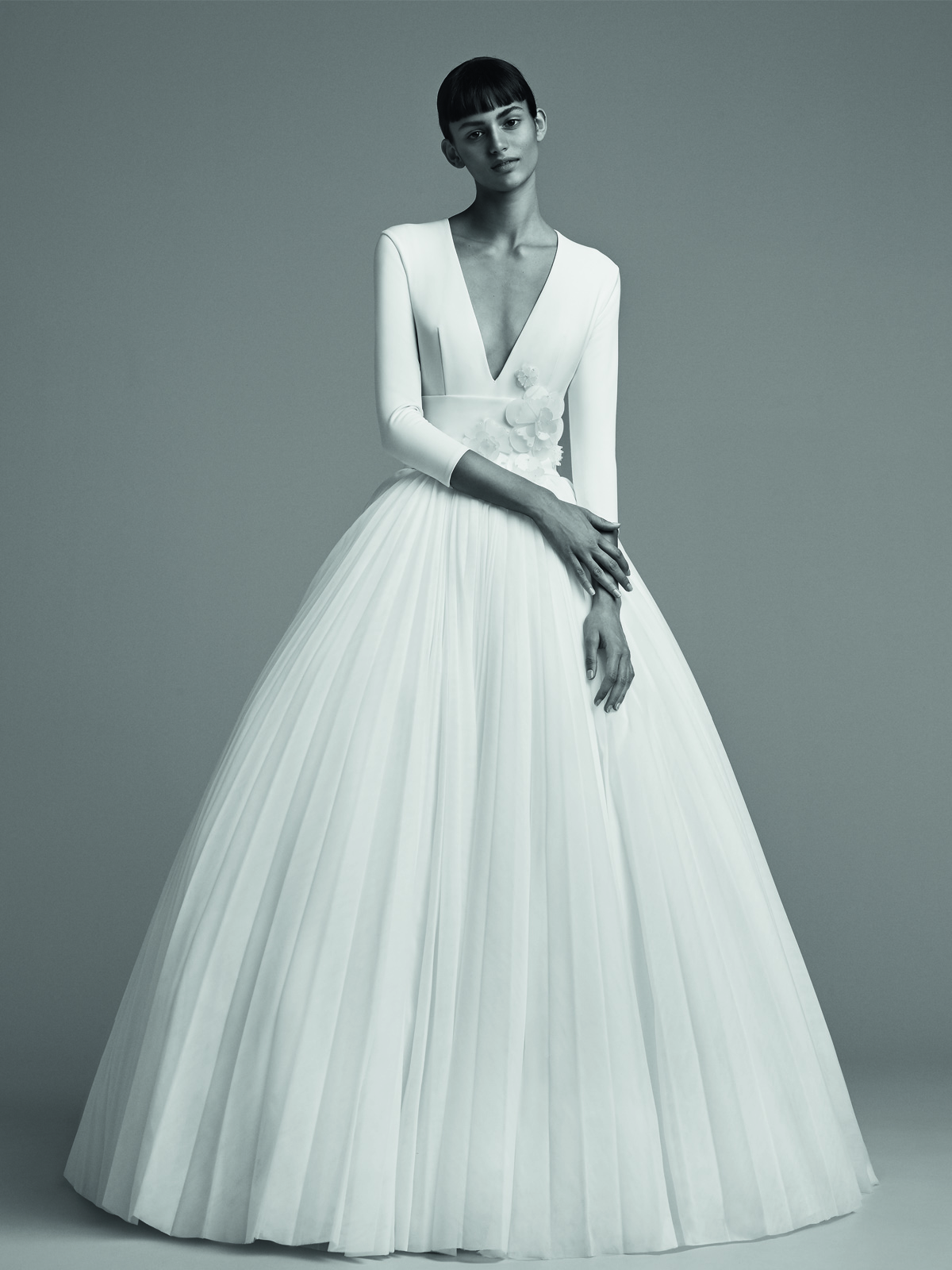 胸元がVカットでスカートには何重ものチュールが重なったプリンセルラインのヴィクター&ロルフ・マリアージュの白いウェディングドレス
