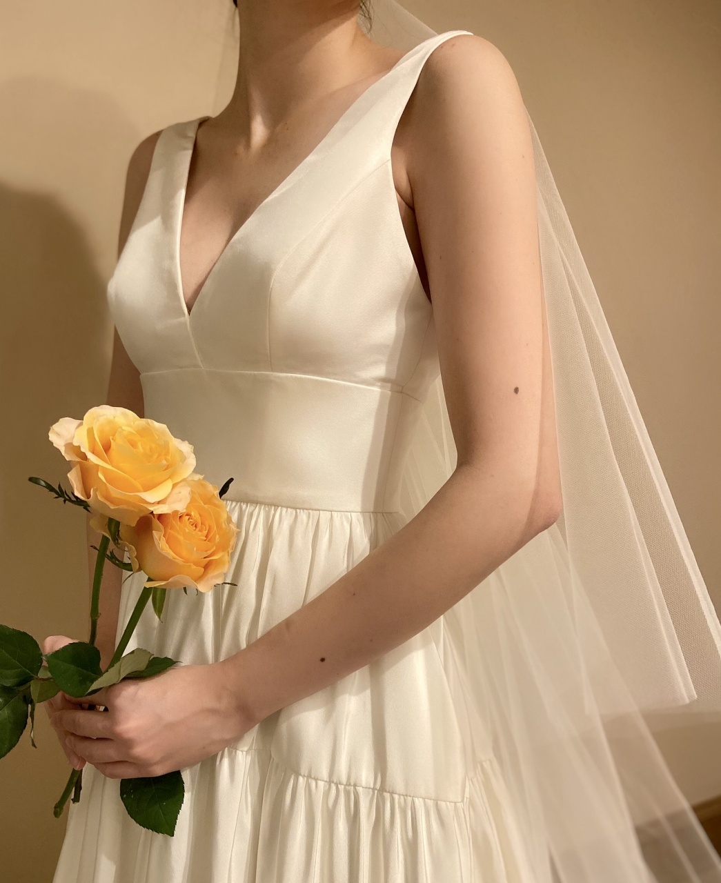 Vカットの胸元がデコルテをすっきりとスタイルアップしてくれるAラインの肩付きウェディングドレス