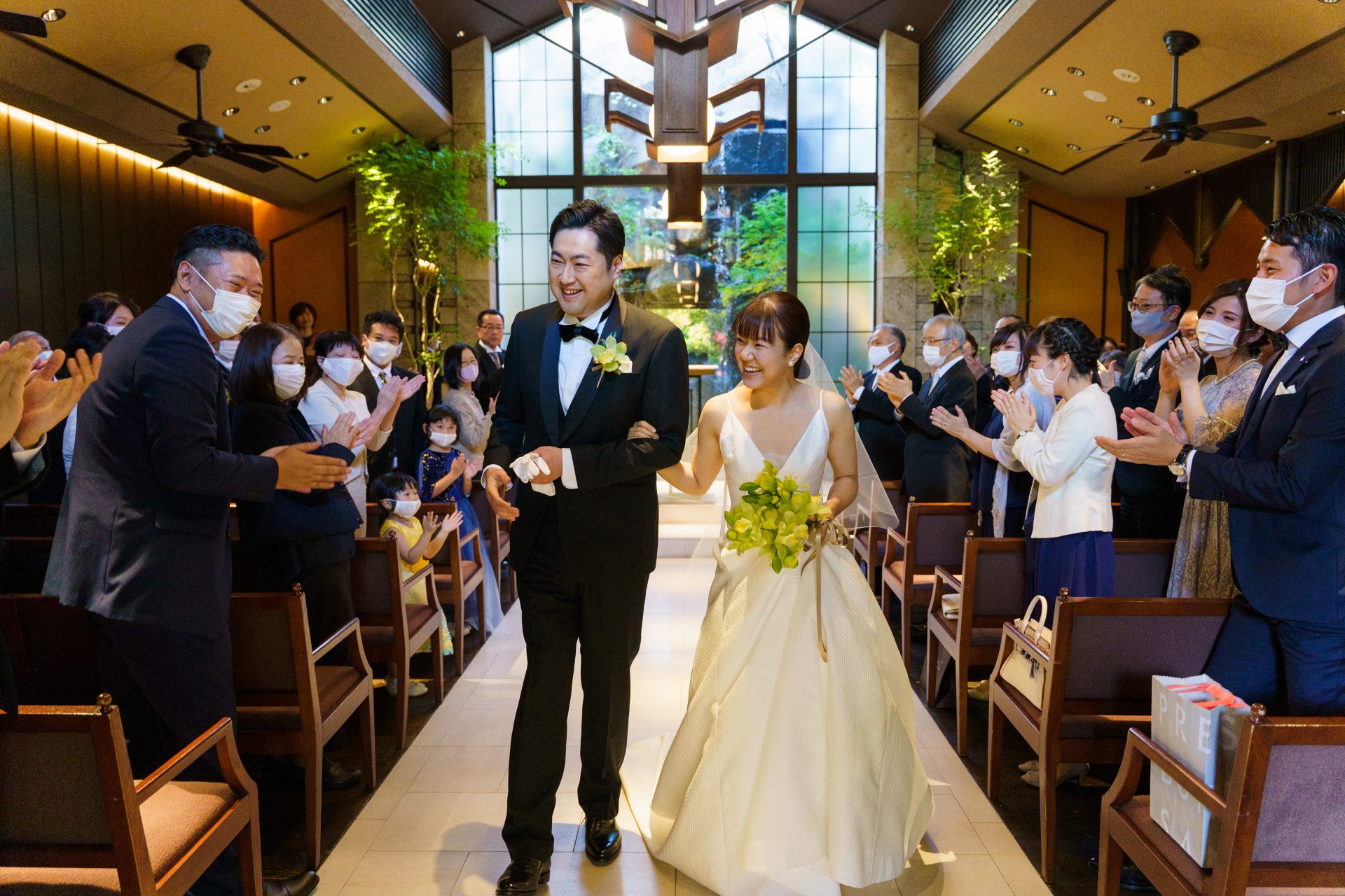 ゲストからの愛に溢れた祝福の中バージンロードを歩くご新郎様ご新婦様