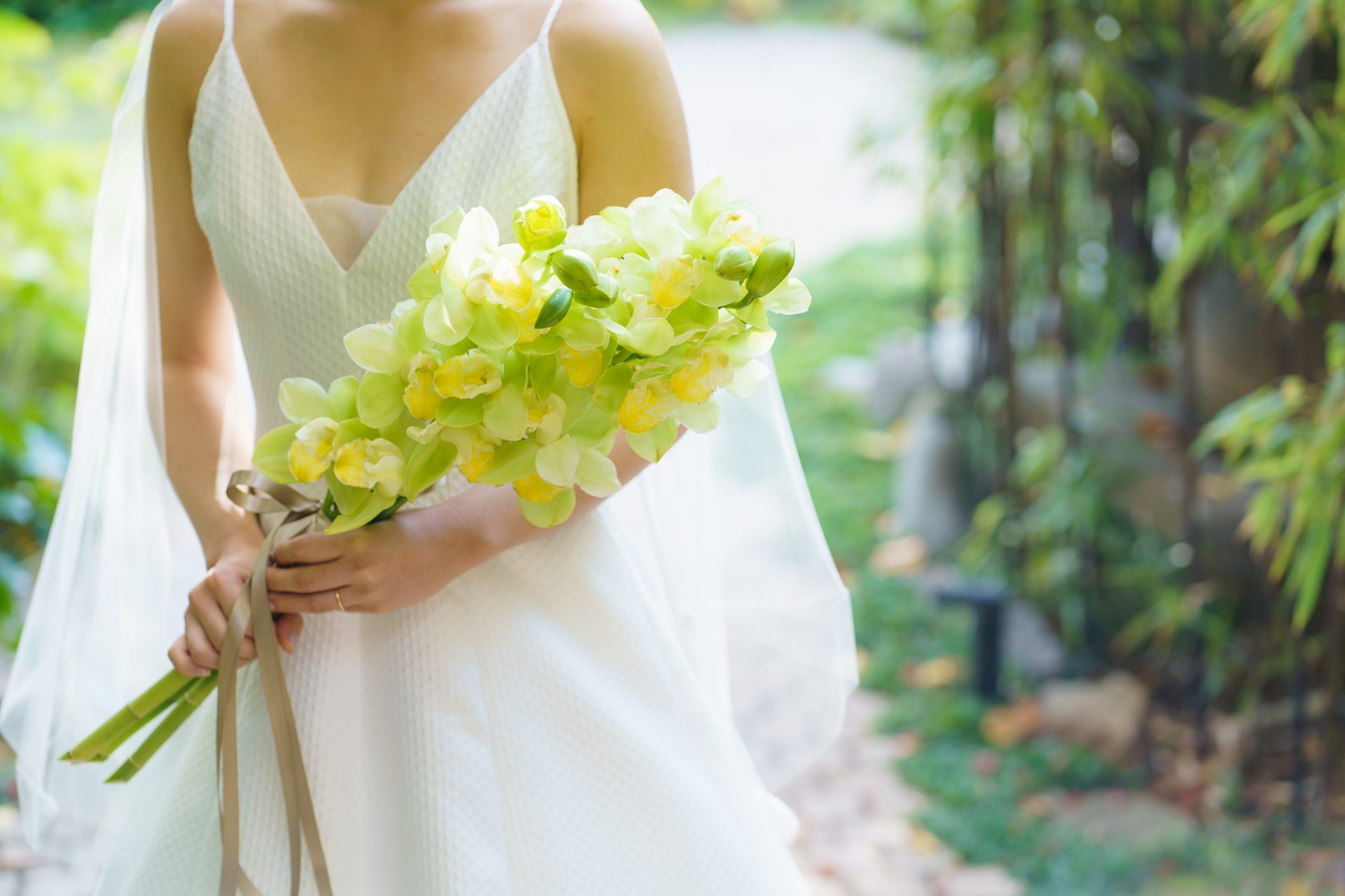 シンプルなAラインのウェディングドレスにマッチするフレッシュなグリーンのブーケを合わせたご新婦様