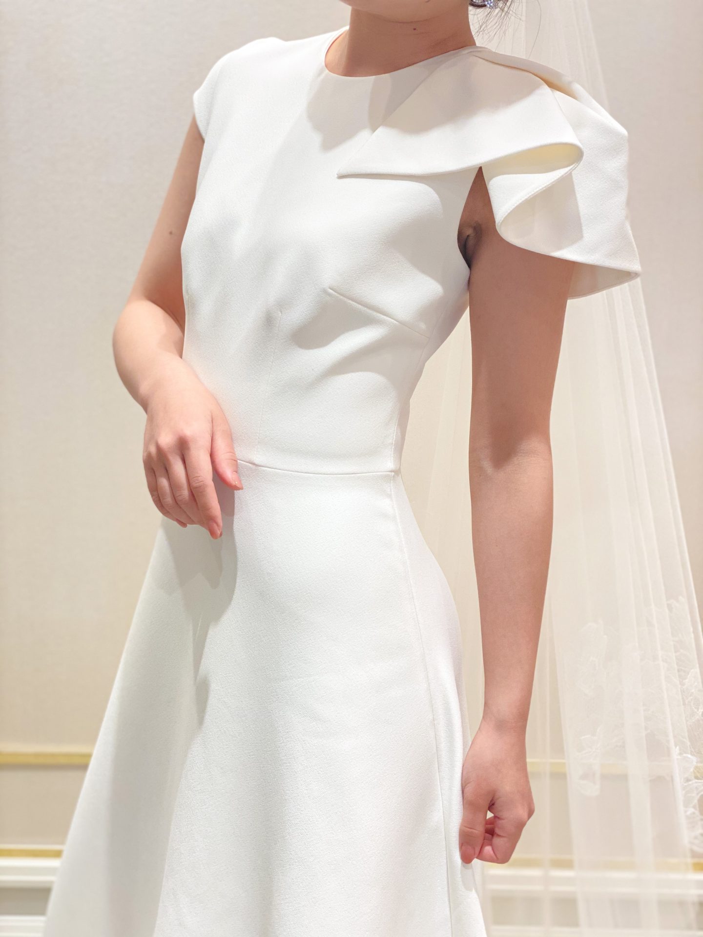 関西大阪にあるインポートウェディングドレスショップ、ザトリートドレッシングよりインポートドレスブランドであるサフィヤの袖元がアシンメトリーなデザインが目を引くシンプルでお洒落なウェディングのご紹介