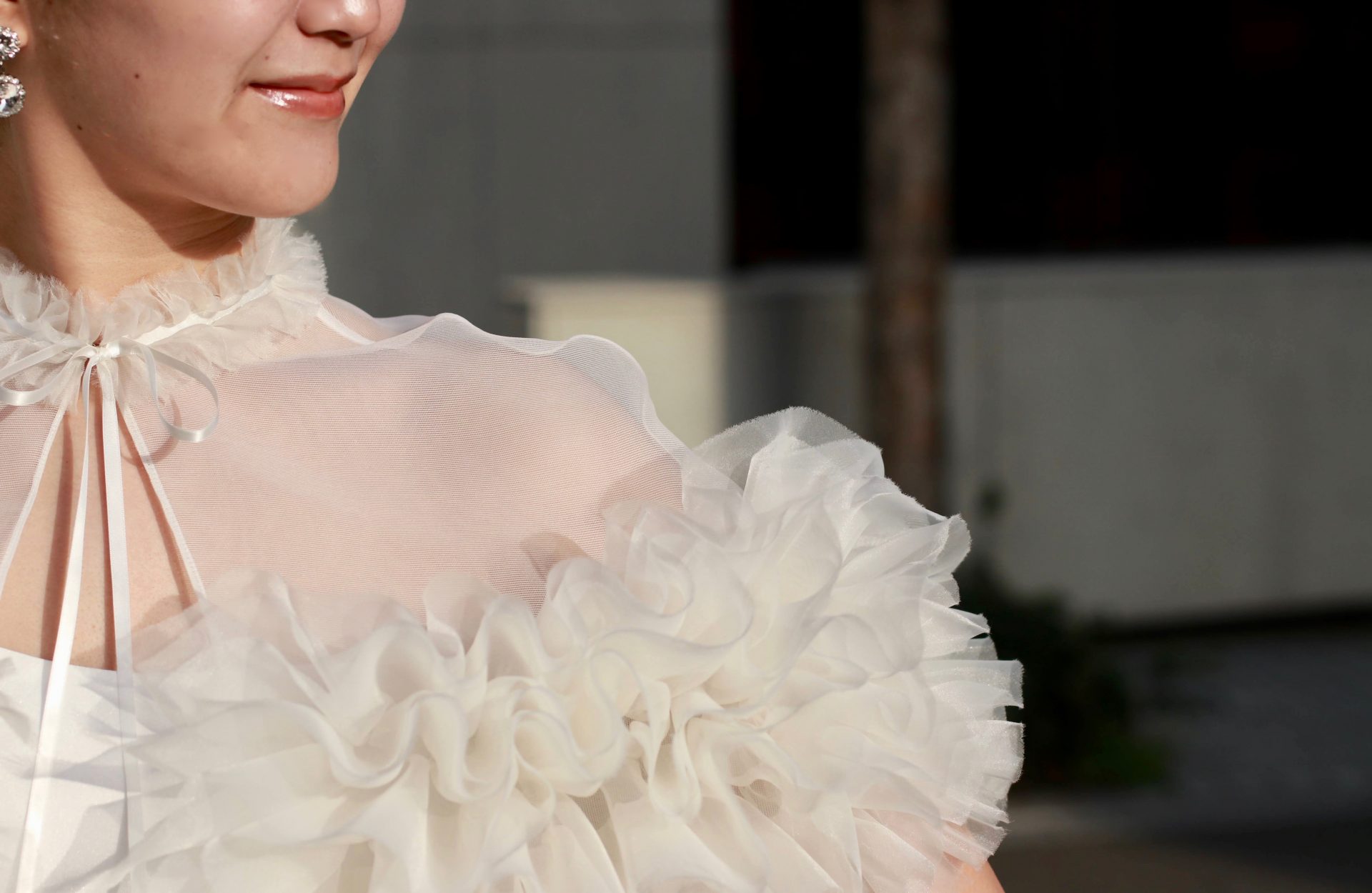 トリートメゾンフォートモコイズミのラッフルチュールのボレロは立体的で華やかなため、クリエーションズジョルジアンニの小振りのイヤリングを合わせてファッショナブルなコーディネートに仕上げています。