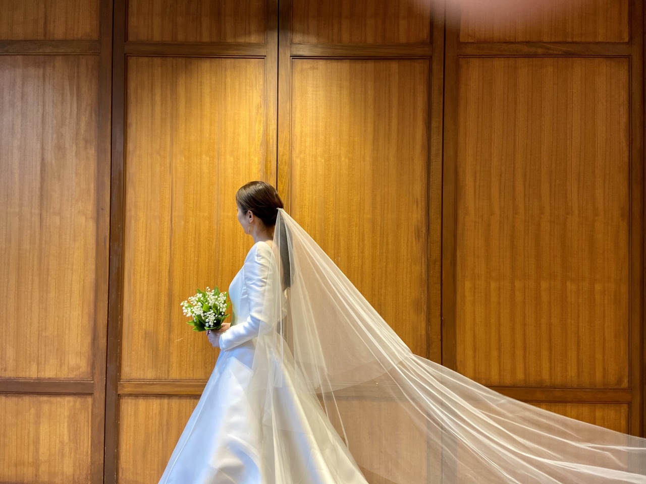 ロングベールを合わせた上品でクラシカルなコーディネートは、ウィズザスタイルの木目調の披露宴会場にもぴったり