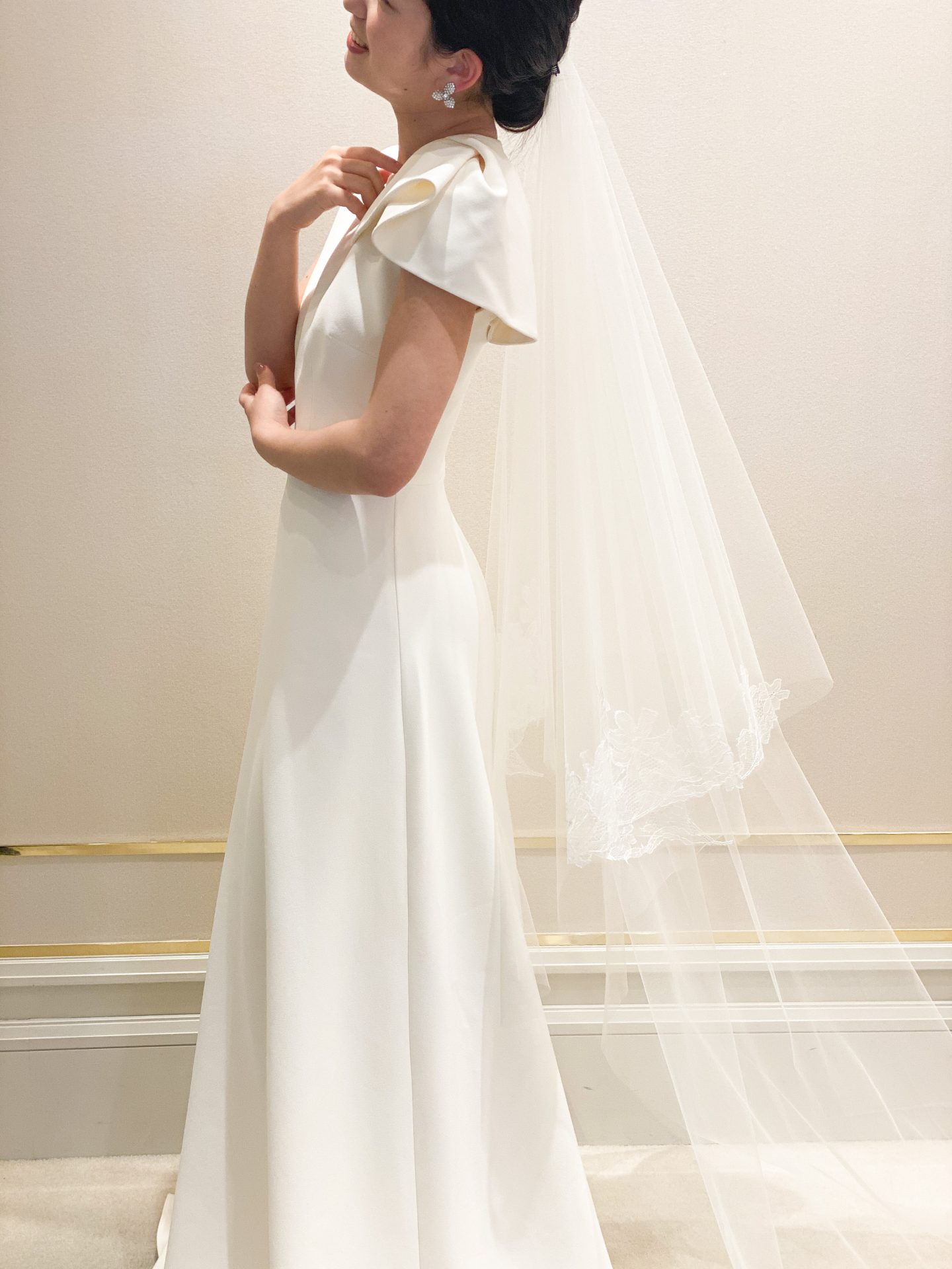 ナチュラルウェディングには首元が詰まっているスリーブデザインのウェディングドレスに合わせてイヤリングはお花がモチーフの小振りのシルバーイヤリングをセレクト、ヘアスタイルはルーズなシニヨンヘアにすることでアットホームなあたたかな印象に