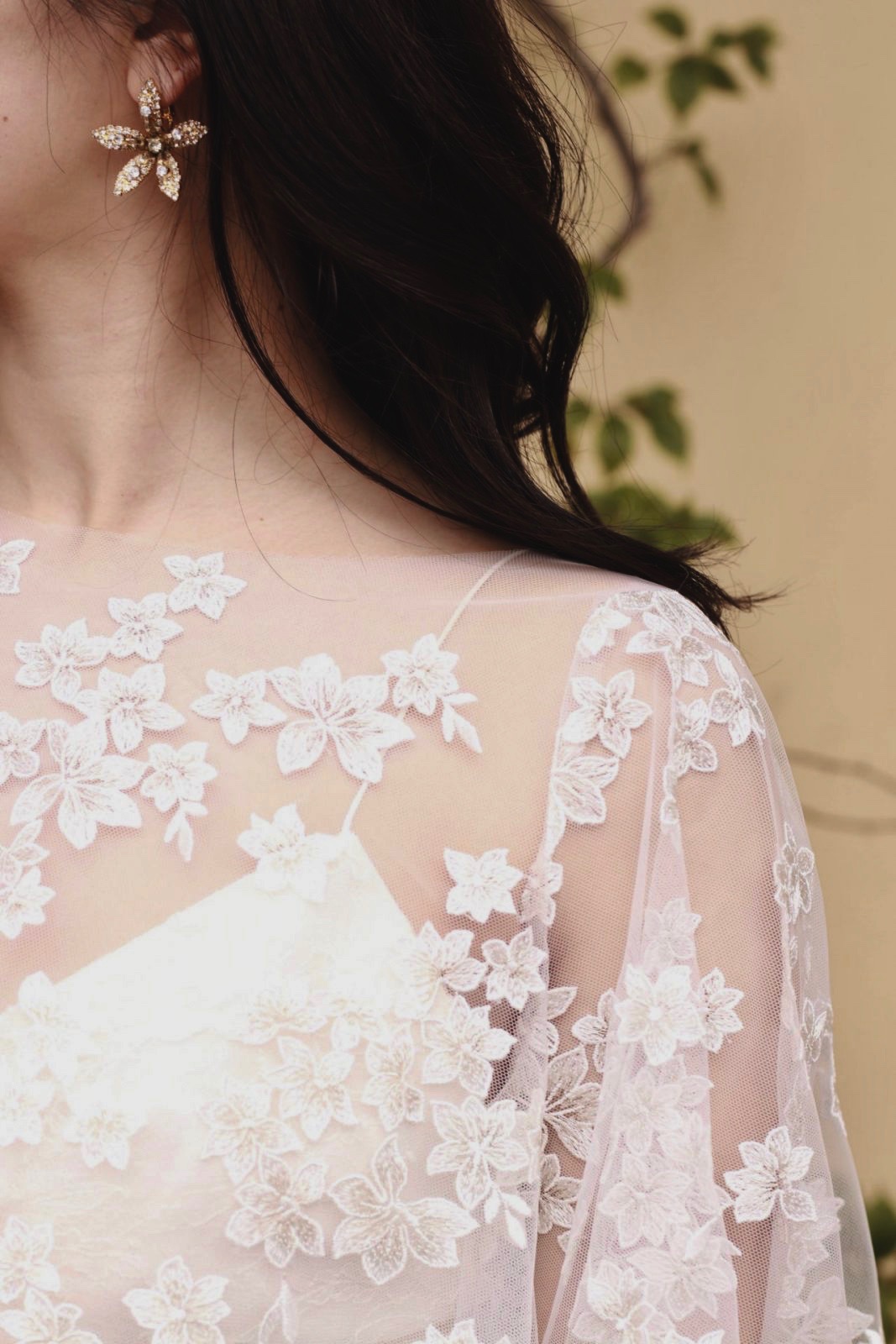 小花の美しいケープのようなボレロには、おしゃれ花嫁に人気のジェニファーベアのゴールドのイヤリングを合わせました。