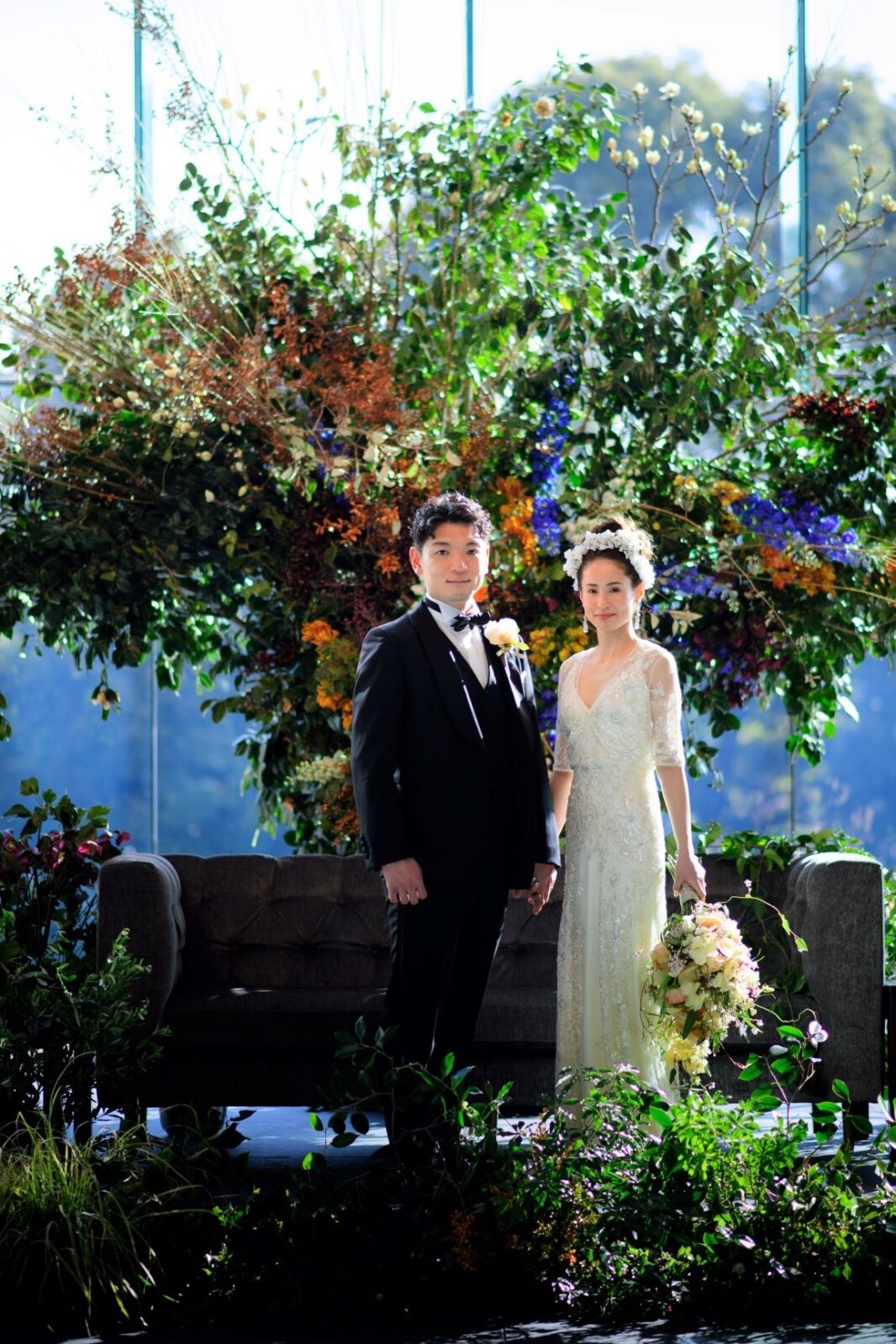 ラグジュアリーな煌めきを放つスレンダーラインのウェディングドレスと、グリーンを基調とした存在感のある会場装花は、パレスホテル東京の天井高で広々とした披露宴会場の中でも圧倒的なインパクトを与えます