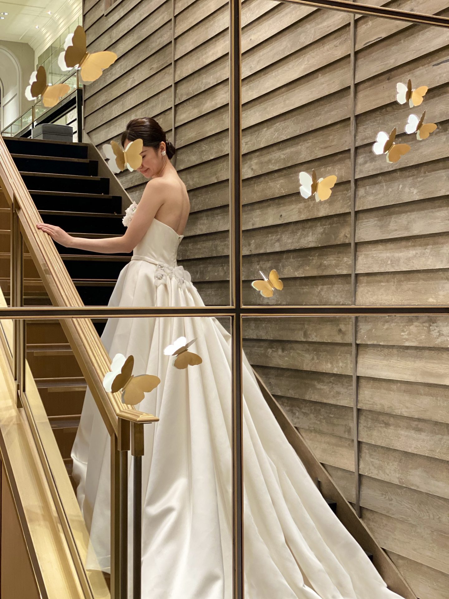 大きな階段のある結婚式場に映えるトレーンが美しいウェディングドレス