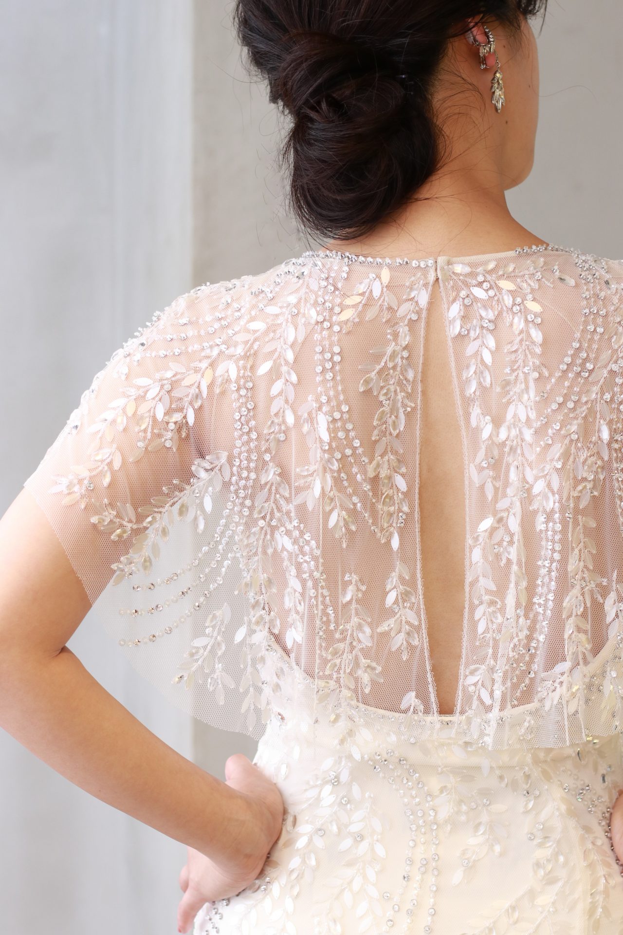 ゴージャスなリーフモチーフのビジューが全身に施され、露出を控えめにするだけでなく、後ろ姿も気を抜かない唯一無二なデザインがゲストの心を掴み、オシャレで大人な女性に人気の1着です