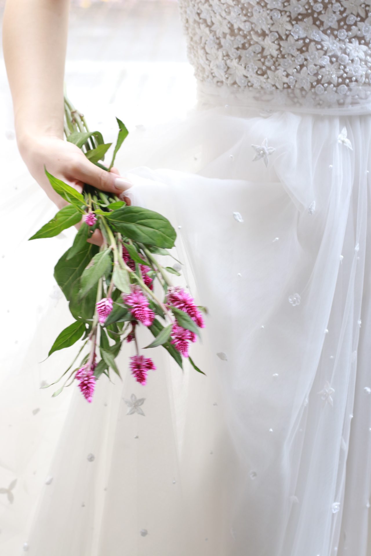 ふんだんにチュールを使用したAラインのウェディングドレスはグリーンと濃いめのピンクのお花を合わせていただくと柔らかい雰囲気を演出していただけます