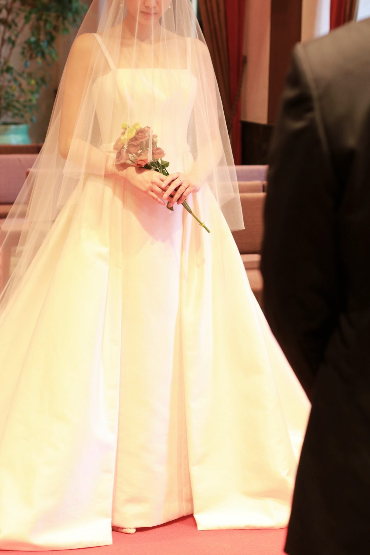 ザトリートドレッシングアディション店の提携会場、赤坂プリンスクラシックハウスのチャペルの赤絨毯のひかれたバージンロードをベールをまとった花嫁が歩みを進める姿に誰もが目を奪われます