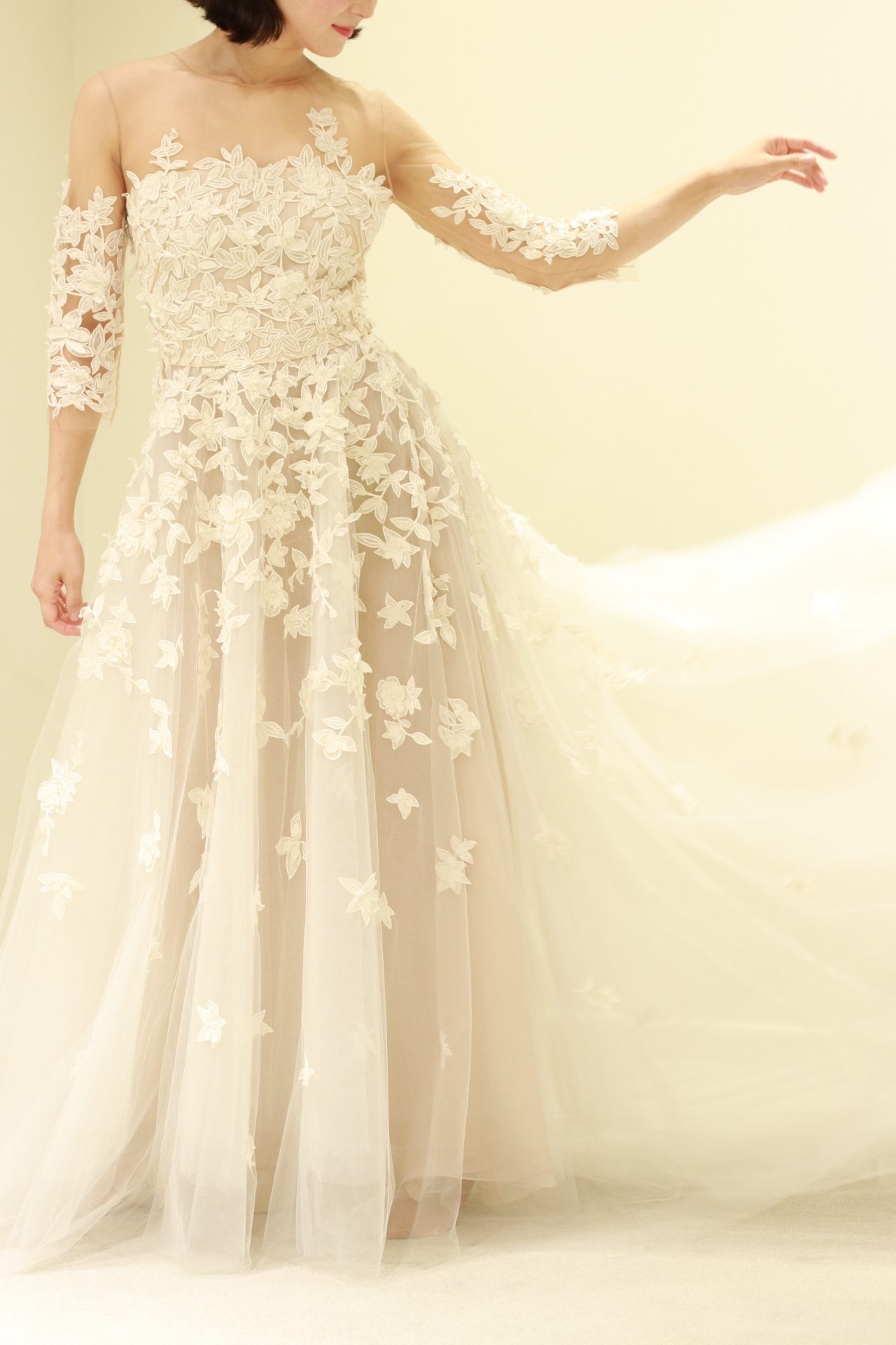 骨格を感じさせずに華奢に見せるゆとりのあるスリーブや、シルクチュールで仕立てられた柔らかいスカートによって大人花嫁の魅力を引き立てるのは、アメリカを代表するドレスブランド、オスカーデラレンタの一着です